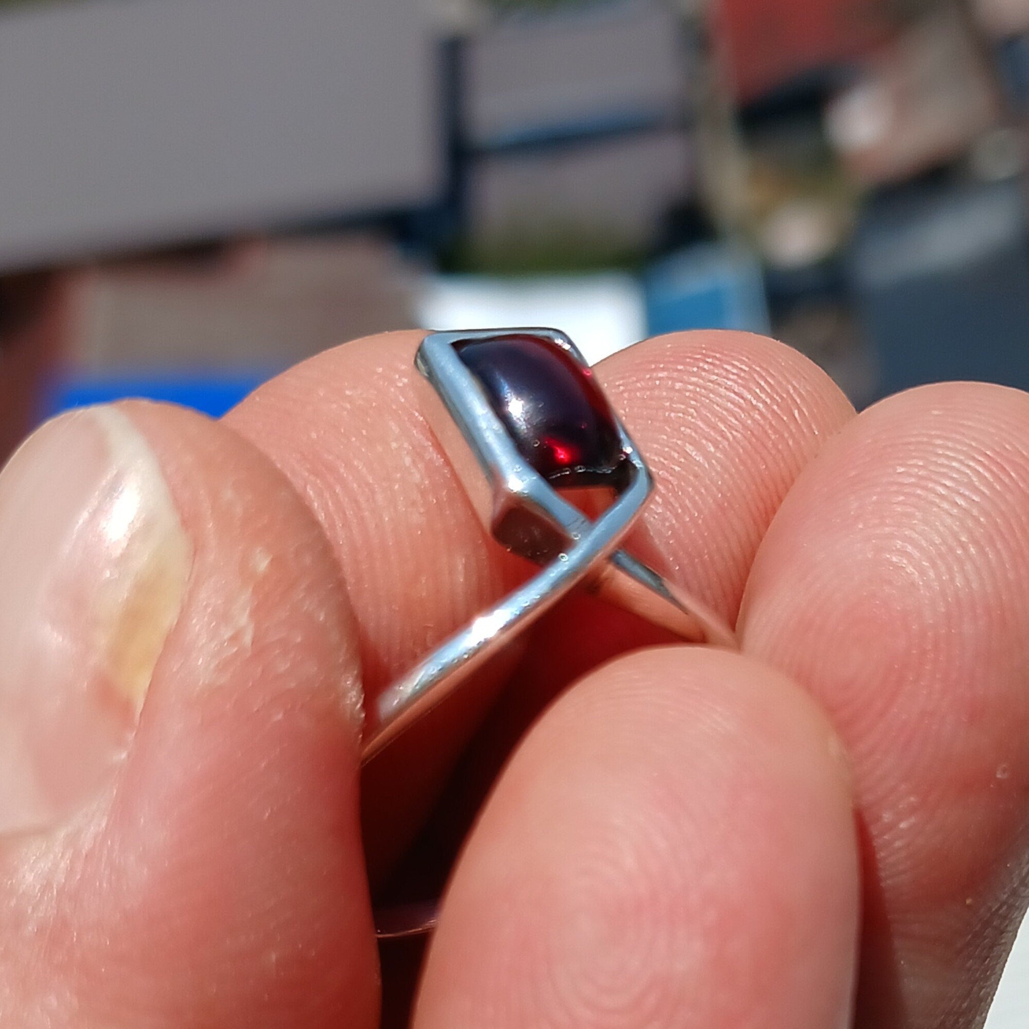 A beautiful Red Garnet Ring featuring a rectangle-shaped cabochon set in a polished sterling silver band, showcasing elegance and simplicity.