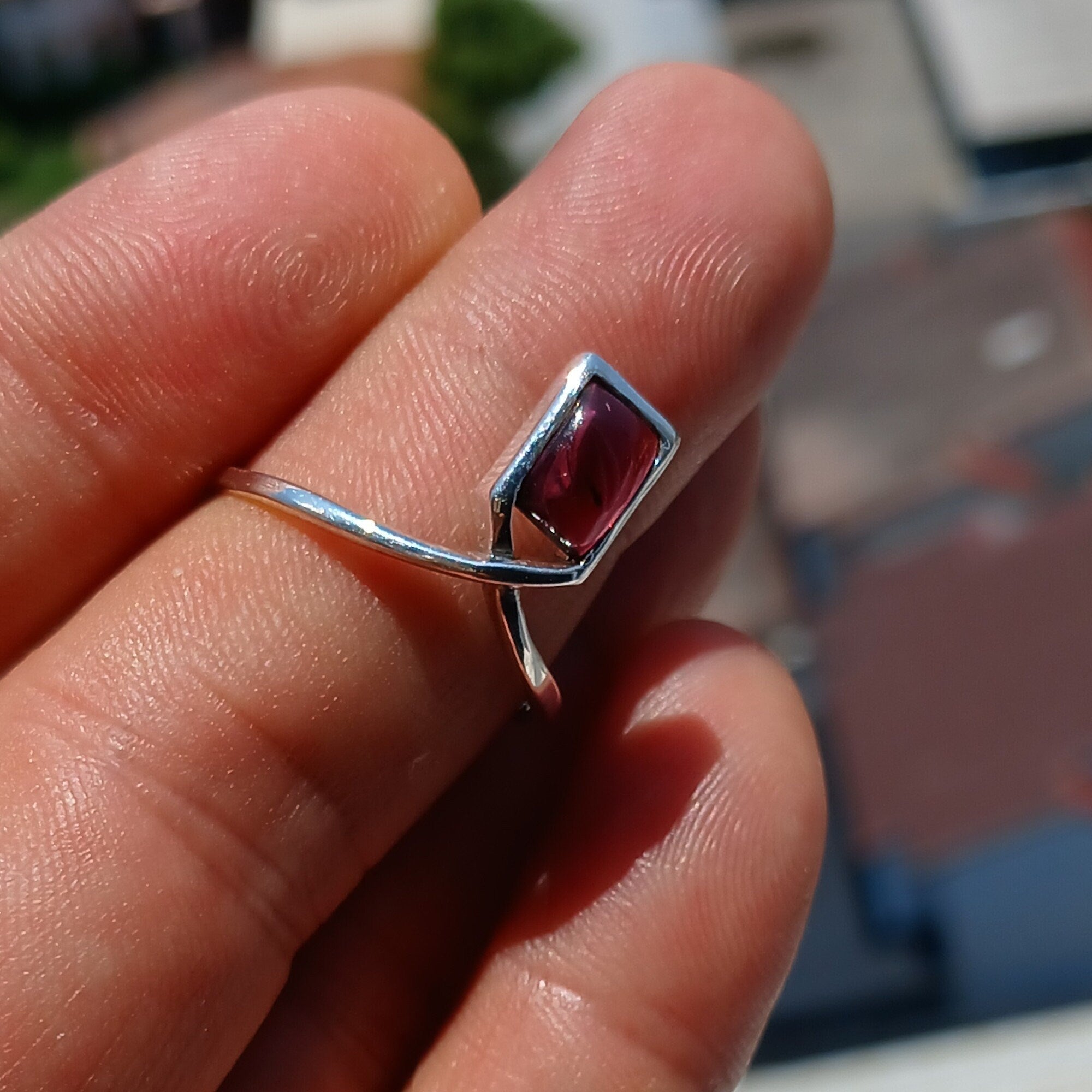 A beautiful Red Garnet Ring featuring a rectangle-shaped cabochon set in a polished sterling silver band, showcasing elegance and simplicity.