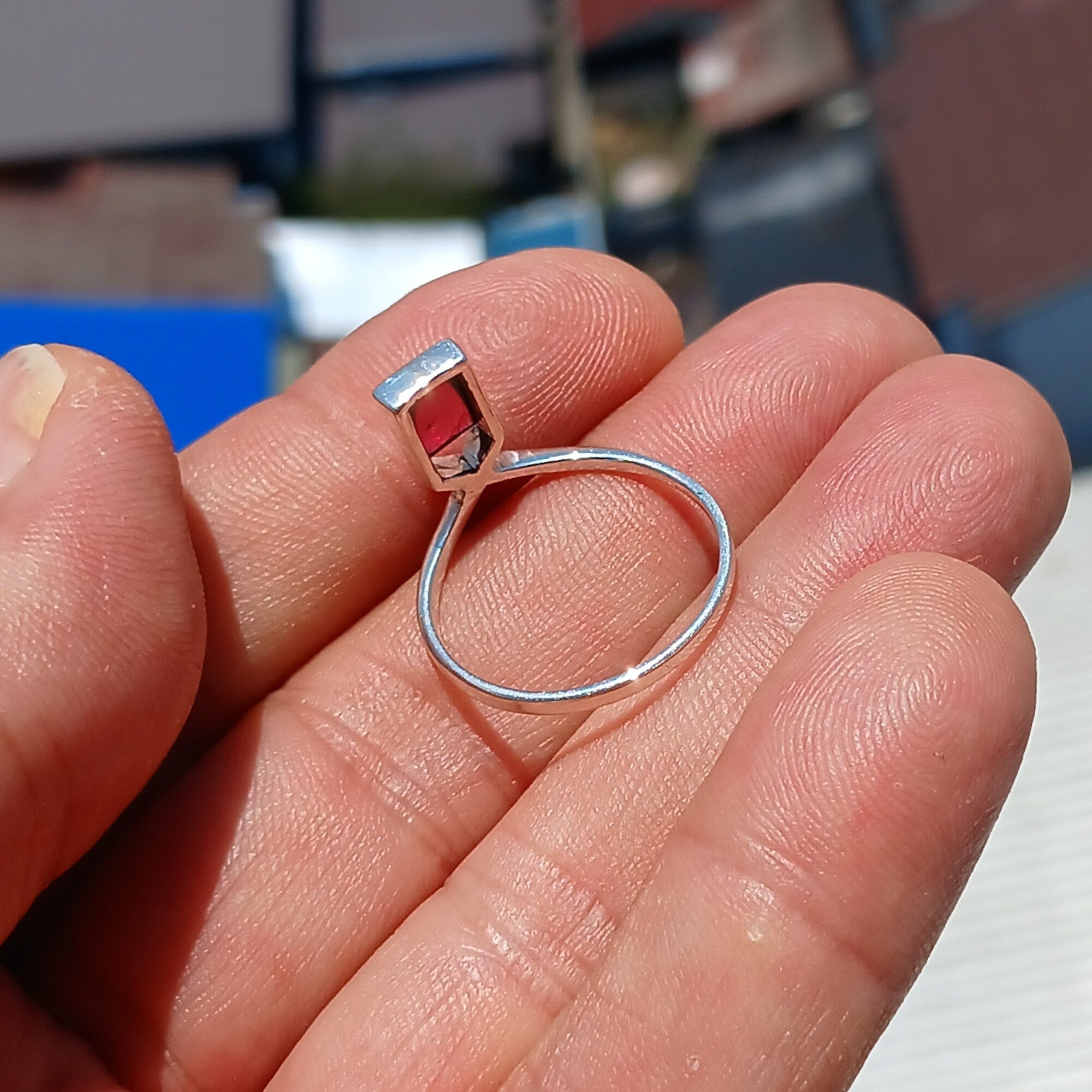 A beautiful Red Garnet Ring featuring a rectangle-shaped cabochon set in a polished sterling silver band, showcasing elegance and simplicity.