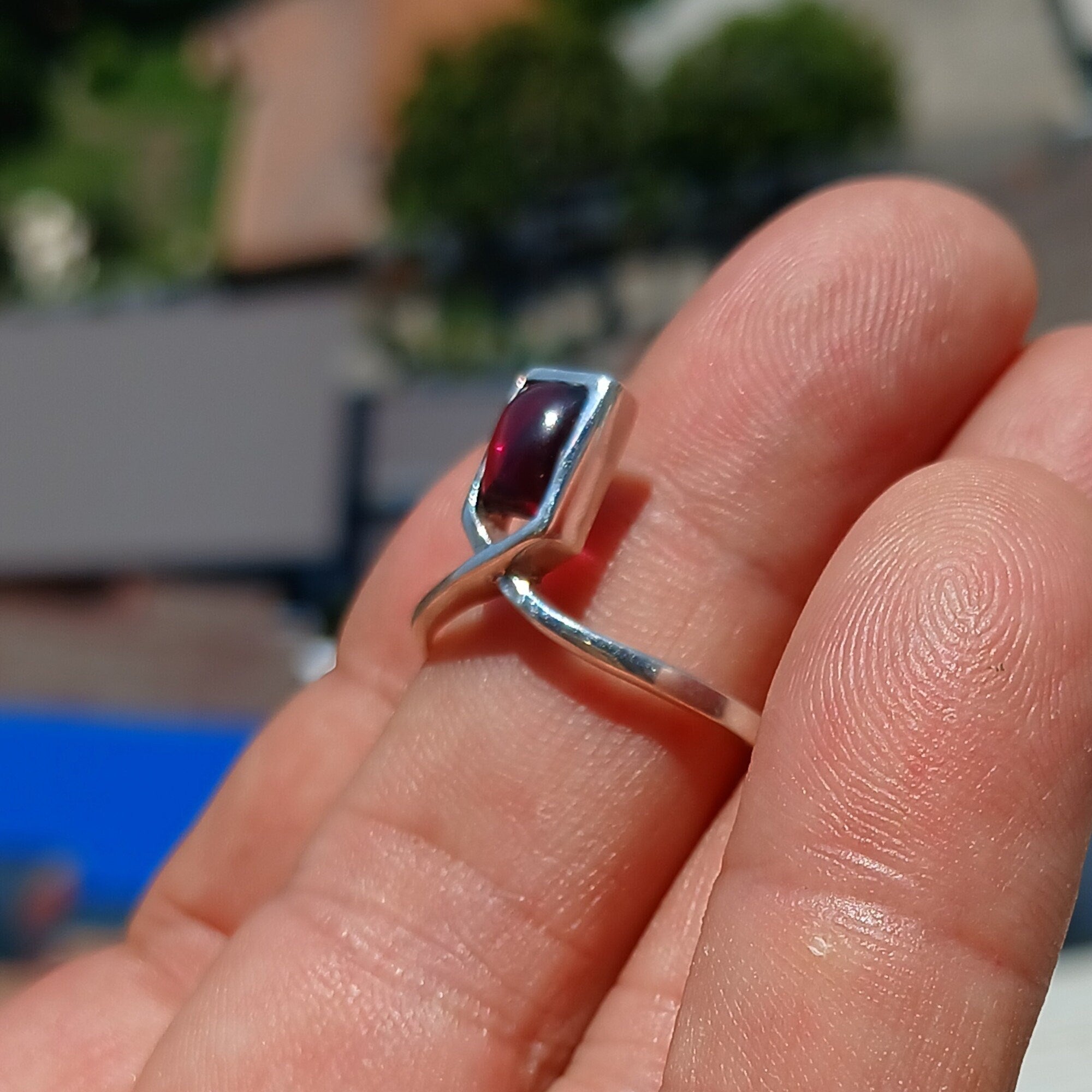 A beautiful Red Garnet Ring featuring a rectangle-shaped cabochon set in a polished sterling silver band, showcasing elegance and simplicity.