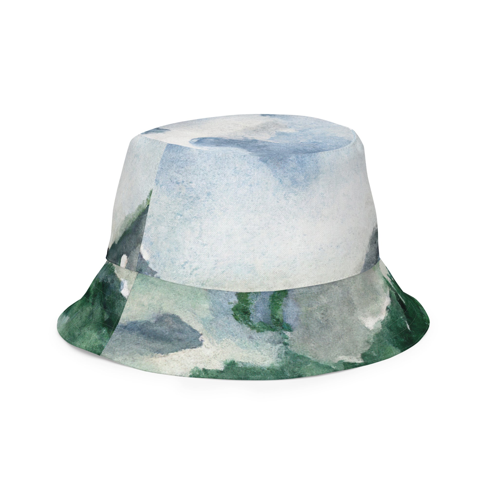 Reversible bucket hat with green mountainside and blue sky print, showcasing a stylish outdoor accessory.