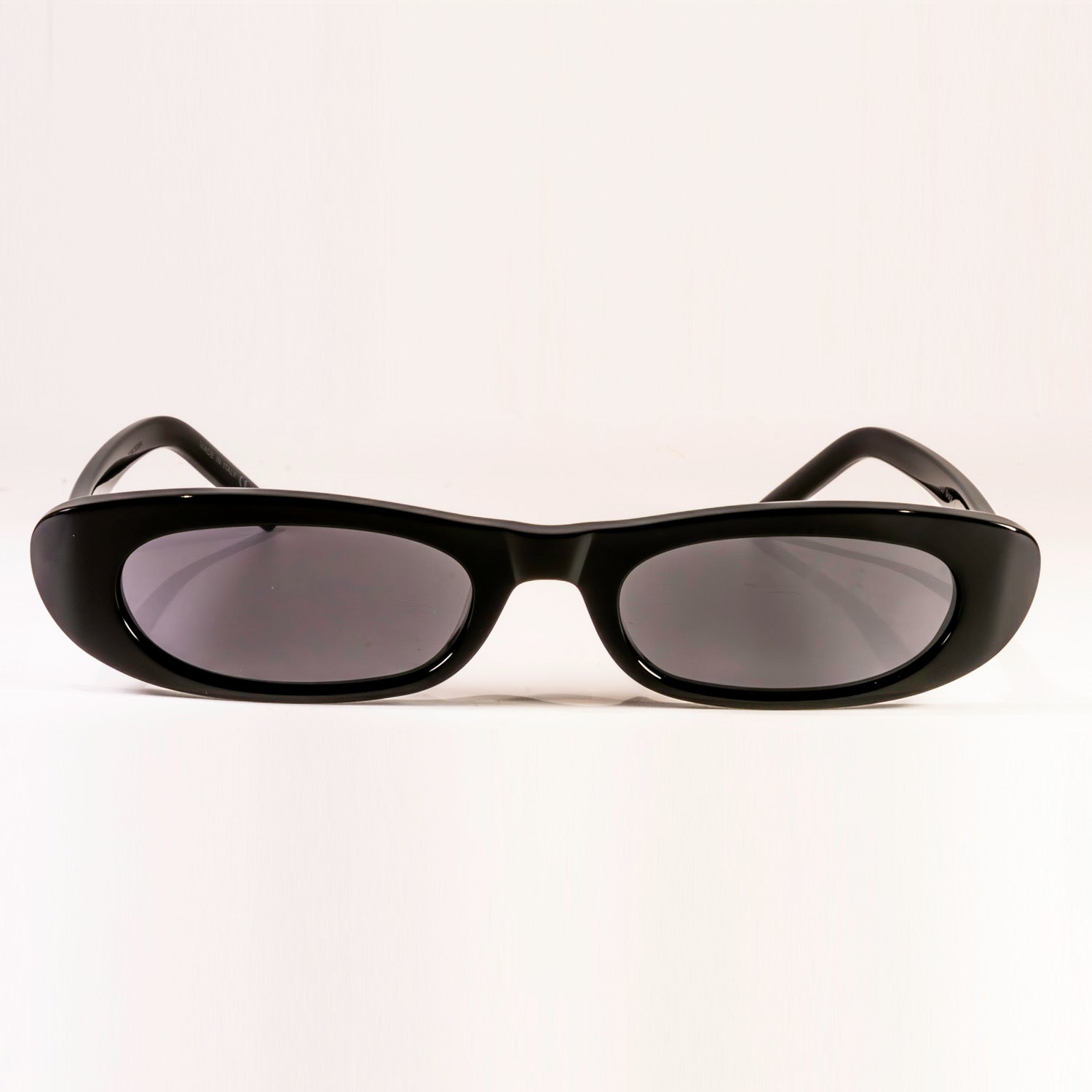 Saint Laurent Sunglasses SL 557 featuring a sleek black plastic frame and nylon lenses in a stylish round-oval shape.