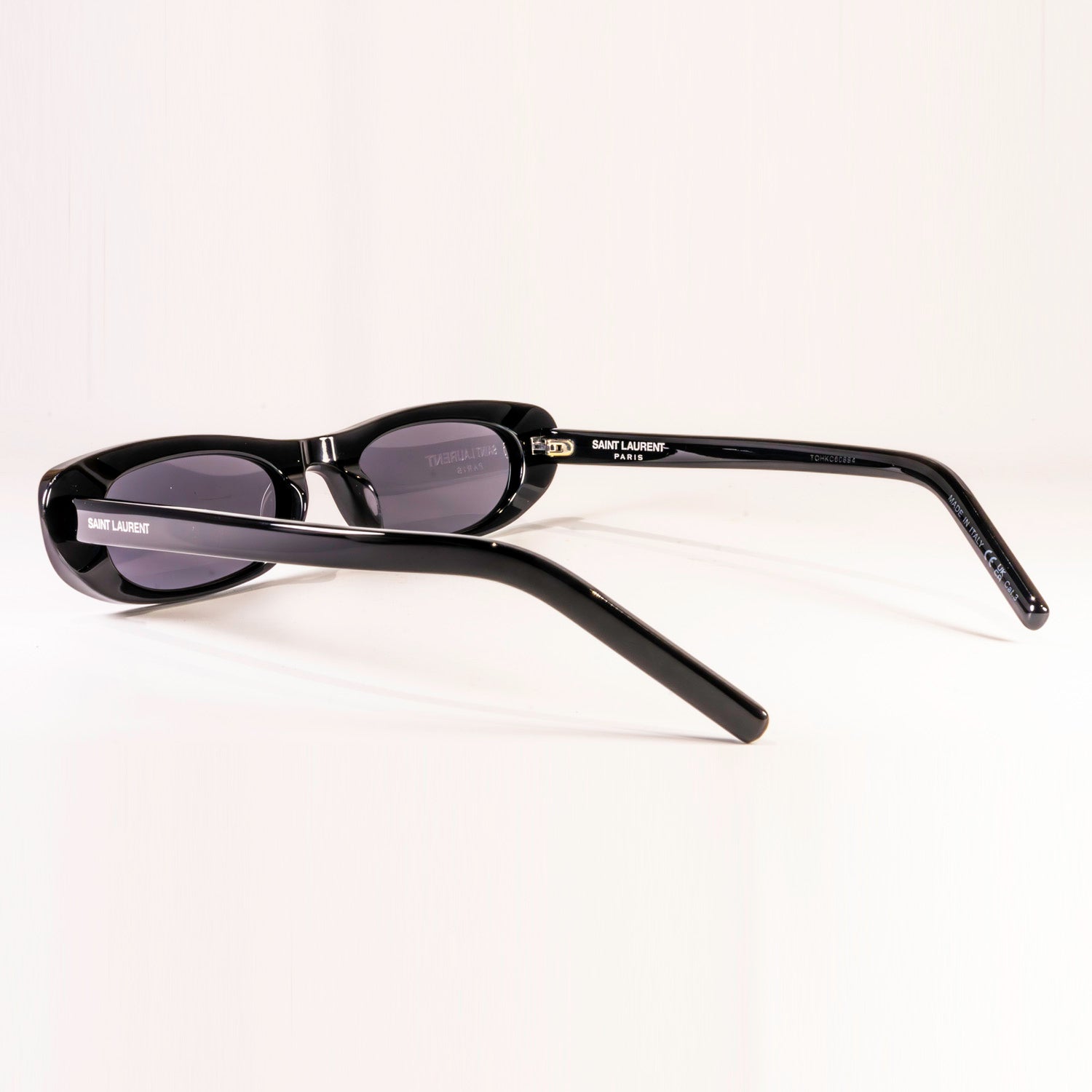 Saint Laurent Sunglasses SL 557 featuring a sleek black plastic frame and nylon lenses in a stylish round-oval shape.
