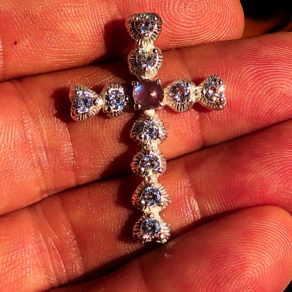 A stunning silver crucifix pendant featuring a moonstone and cubic zirconia, elegantly crafted in sterling silver.