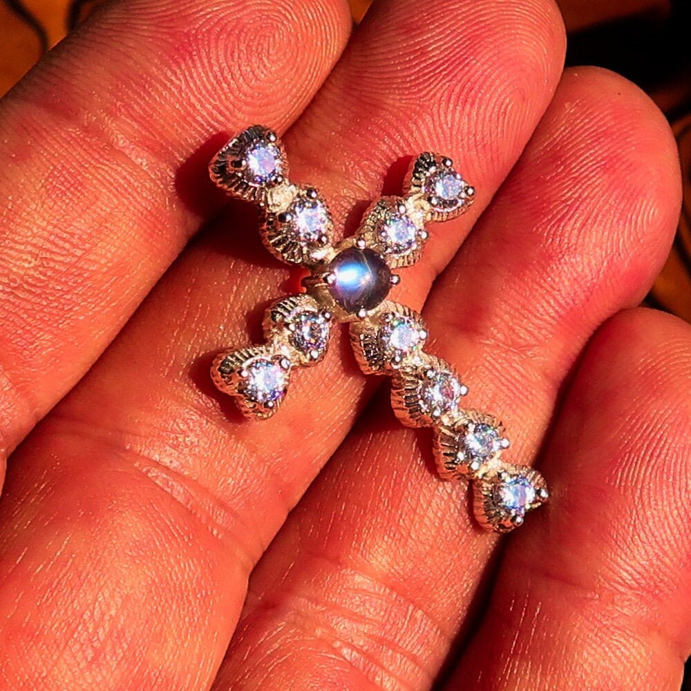 A stunning silver crucifix pendant featuring a moonstone and cubic zirconia, elegantly crafted in sterling silver.
