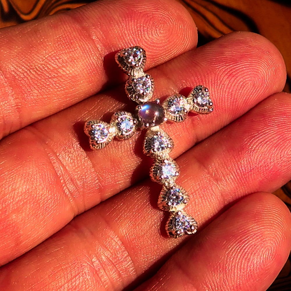 A stunning silver crucifix pendant featuring a moonstone and cubic zirconia, elegantly crafted in sterling silver.