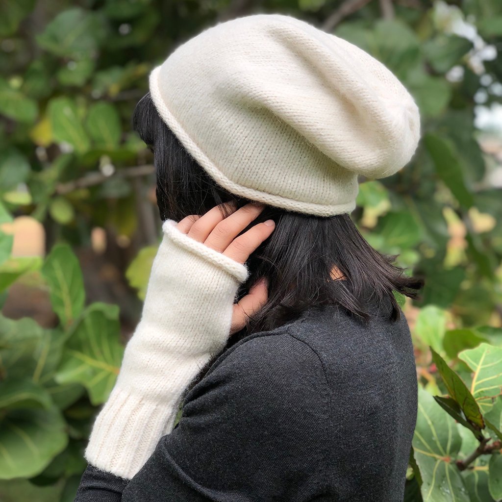 A pair of stylish Snow Essential Knit Alpaca Gloves in snow color, featuring a fingerless design and ribbed cuffs, handmade in Peru.