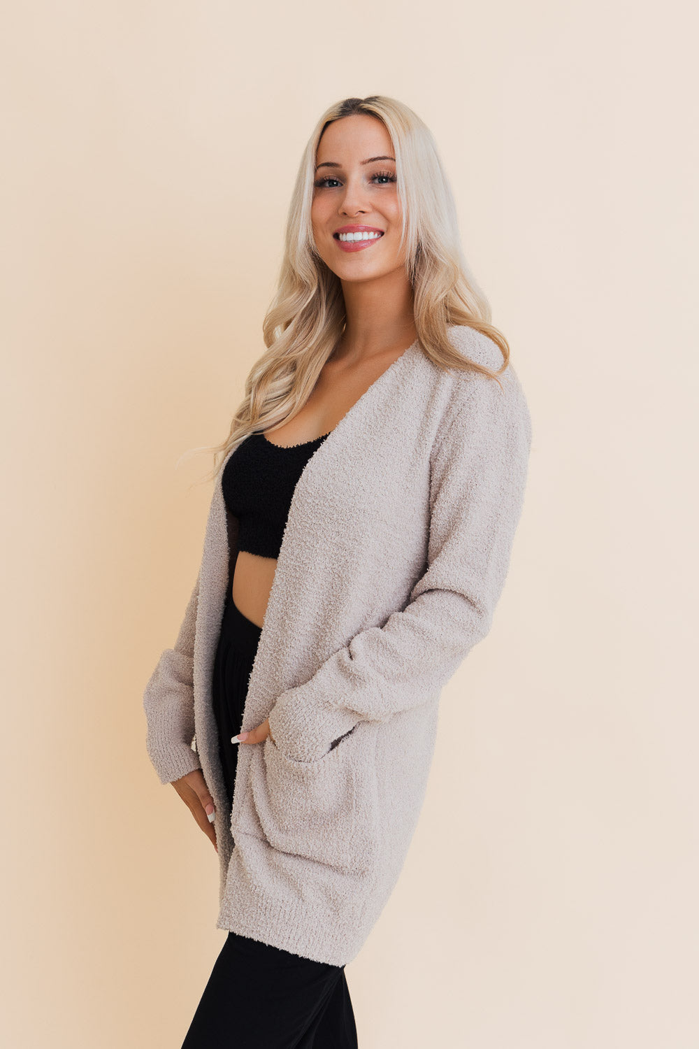 A stylish longline cardigan made of soft boucle fabric, featuring pockets and a cozy design, perfect for layering.