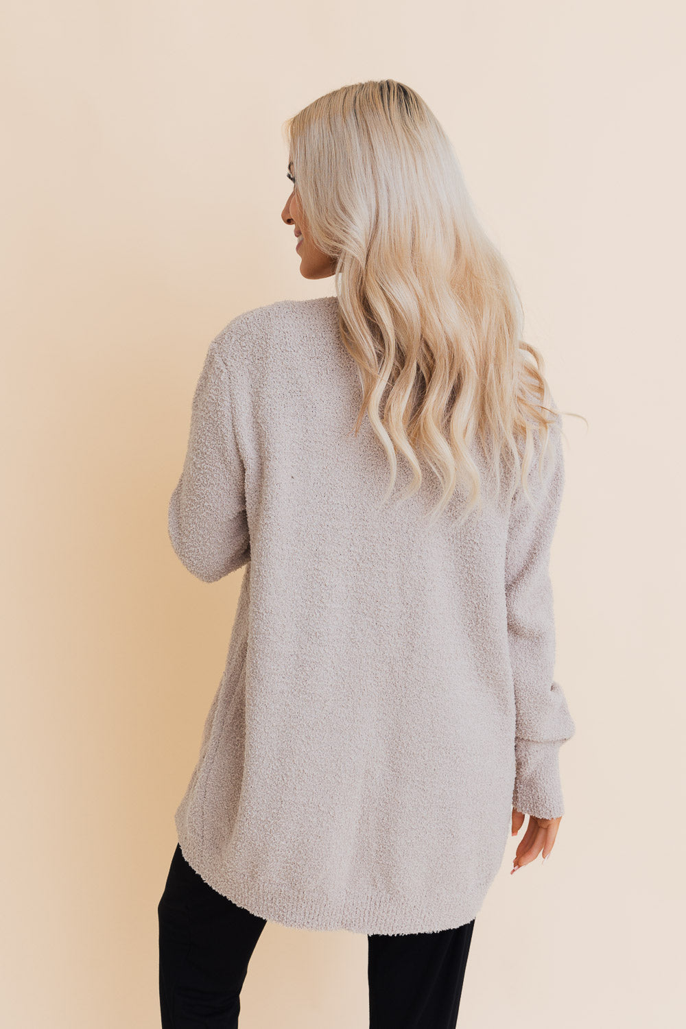 A stylish longline cardigan made of soft boucle fabric, featuring pockets and a cozy design, perfect for layering.