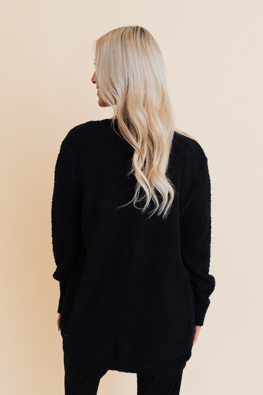 A stylish longline cardigan made of soft boucle fabric, featuring pockets and a cozy design, perfect for layering.