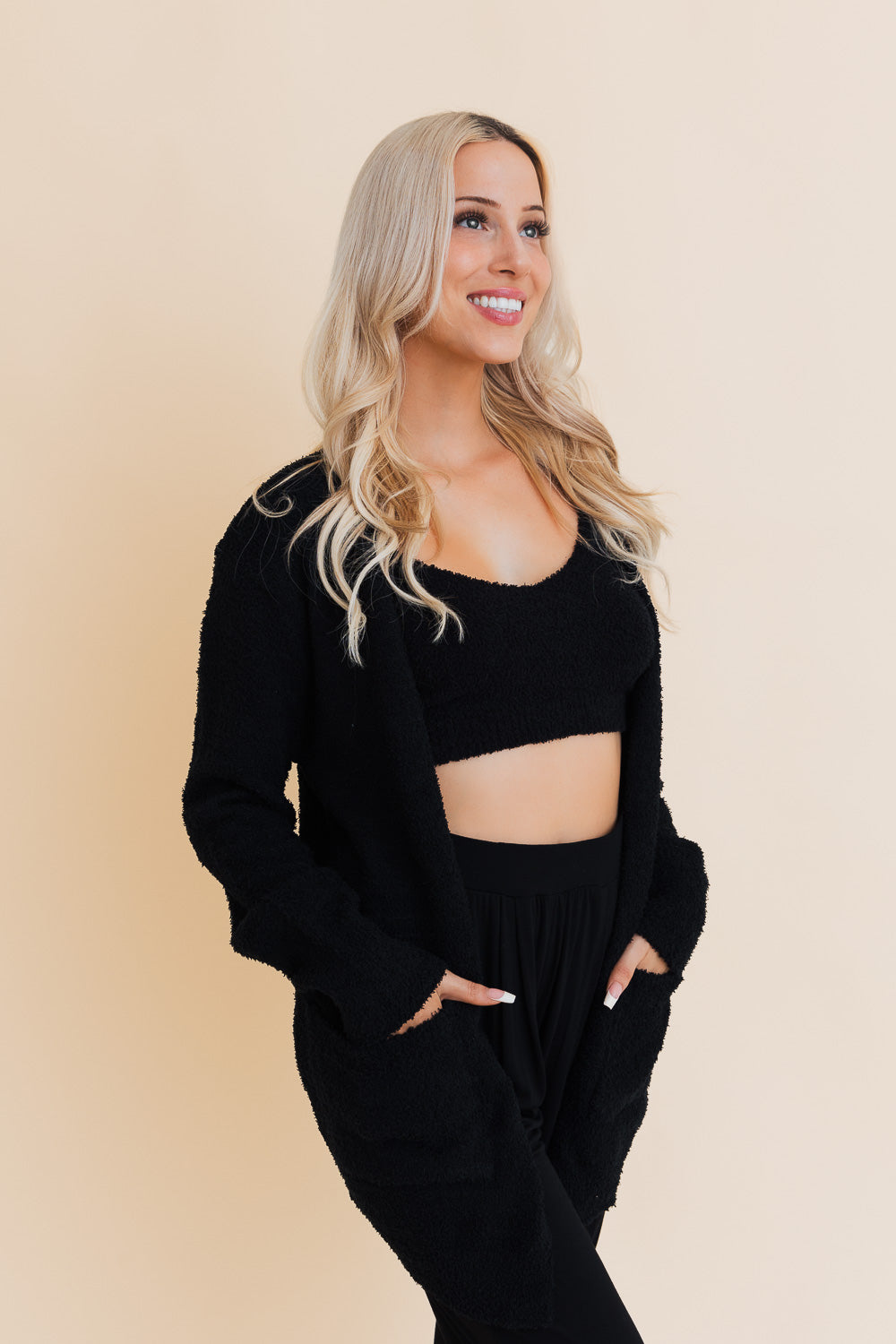 A stylish longline cardigan made of soft boucle fabric, featuring pockets and a cozy design, perfect for layering.