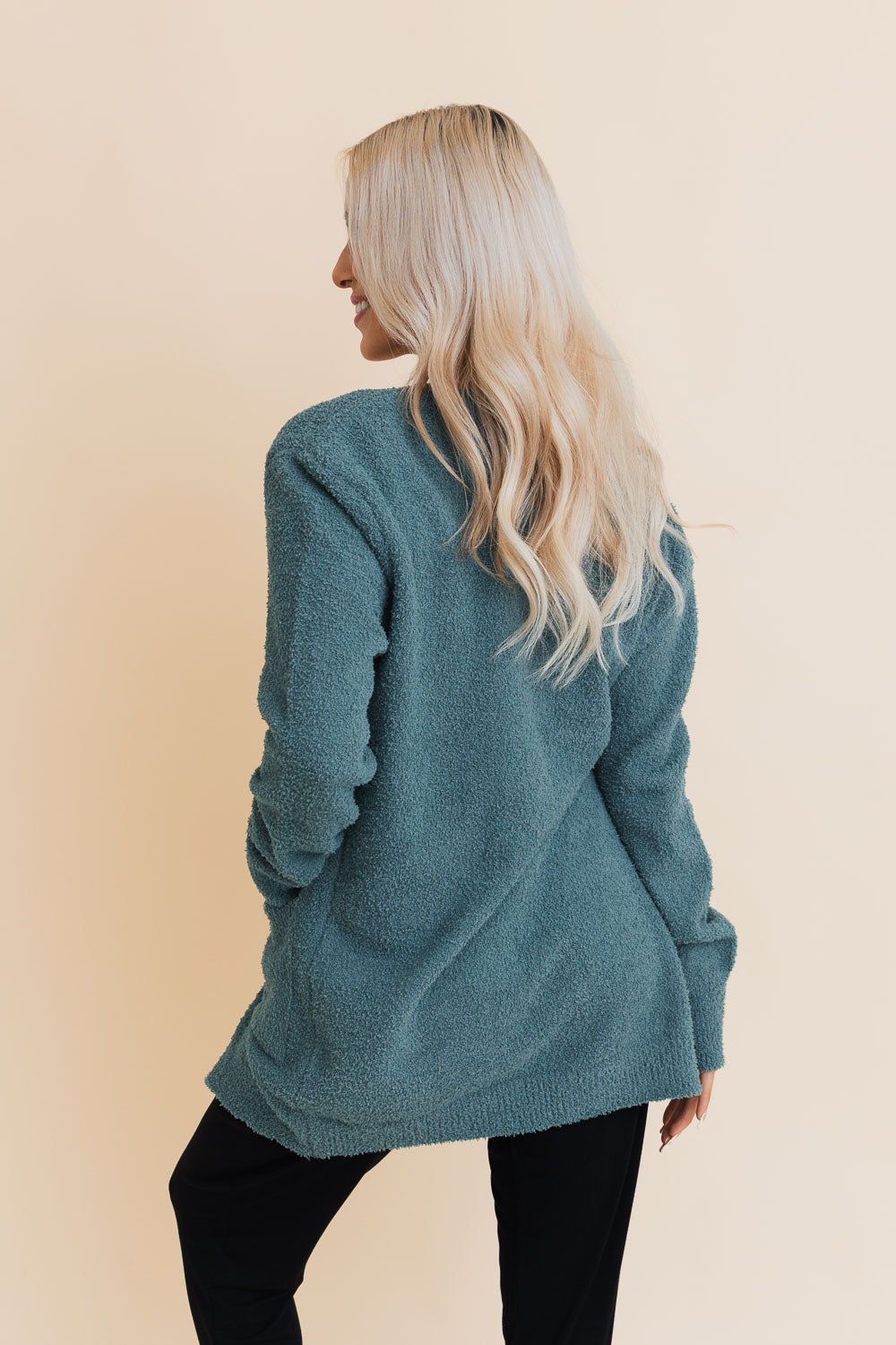 A stylish longline cardigan made of soft boucle fabric, featuring pockets and a cozy design, perfect for layering.