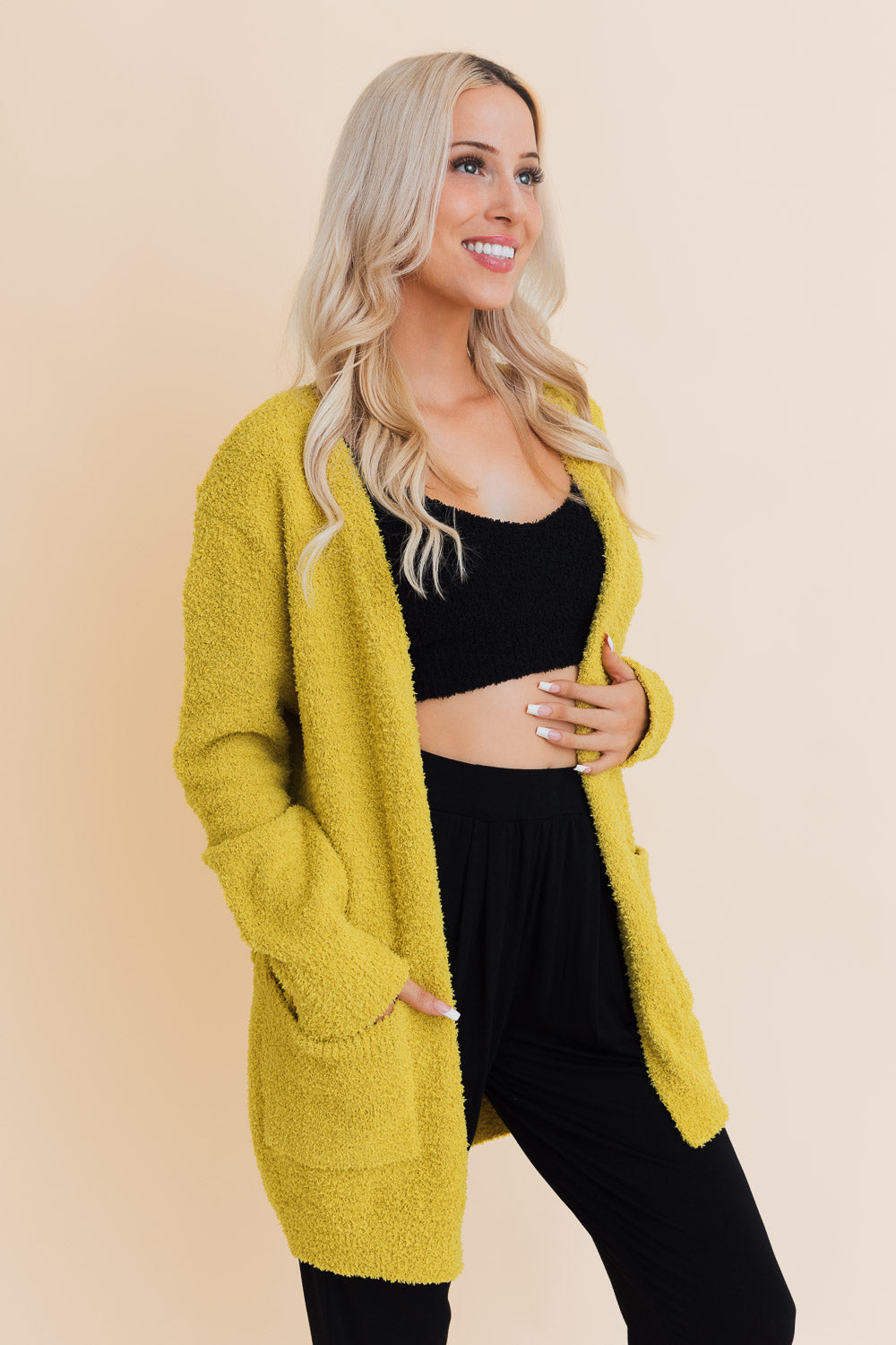 A stylish longline cardigan made of soft boucle fabric, featuring pockets and a cozy design, perfect for layering.