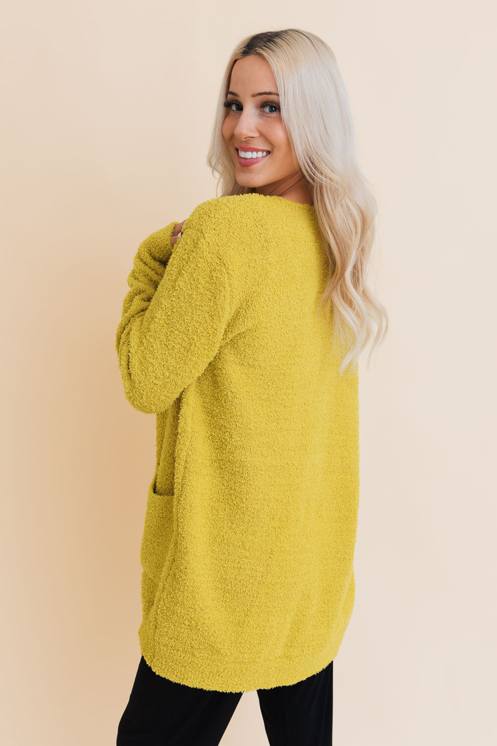 A stylish longline cardigan made of soft boucle fabric, featuring pockets and a cozy design, perfect for layering.