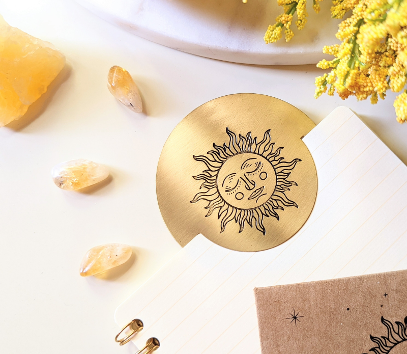 Solar Radiance Bookmark made of unpolished brass, featuring a circular design, perfect for marking pages in books or planners.