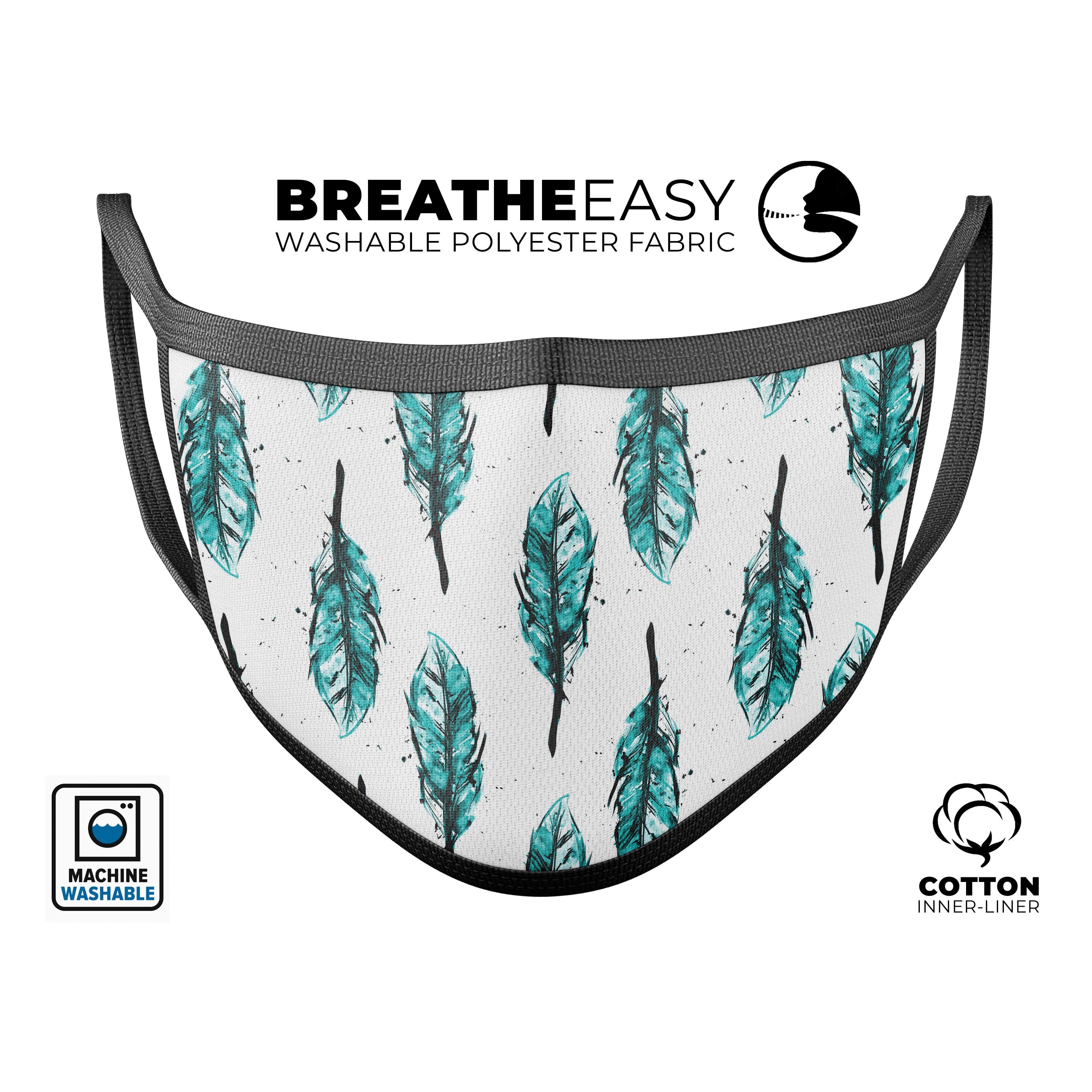 A vibrant teal watercolor feather face mask, showcasing a unique design and adjustable ear loops, made in the USA.