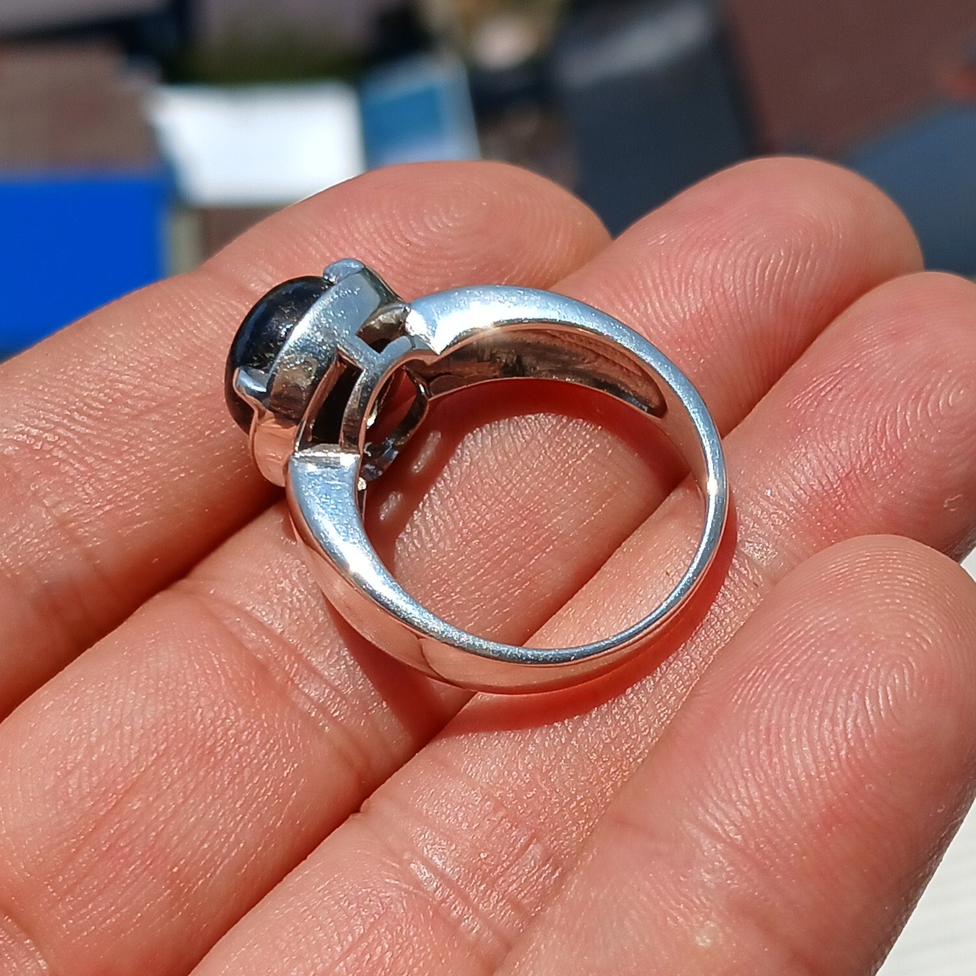 A handcrafted sterling silver ring featuring a round dark Labradorite stone, showcasing its unique design and craftsmanship.