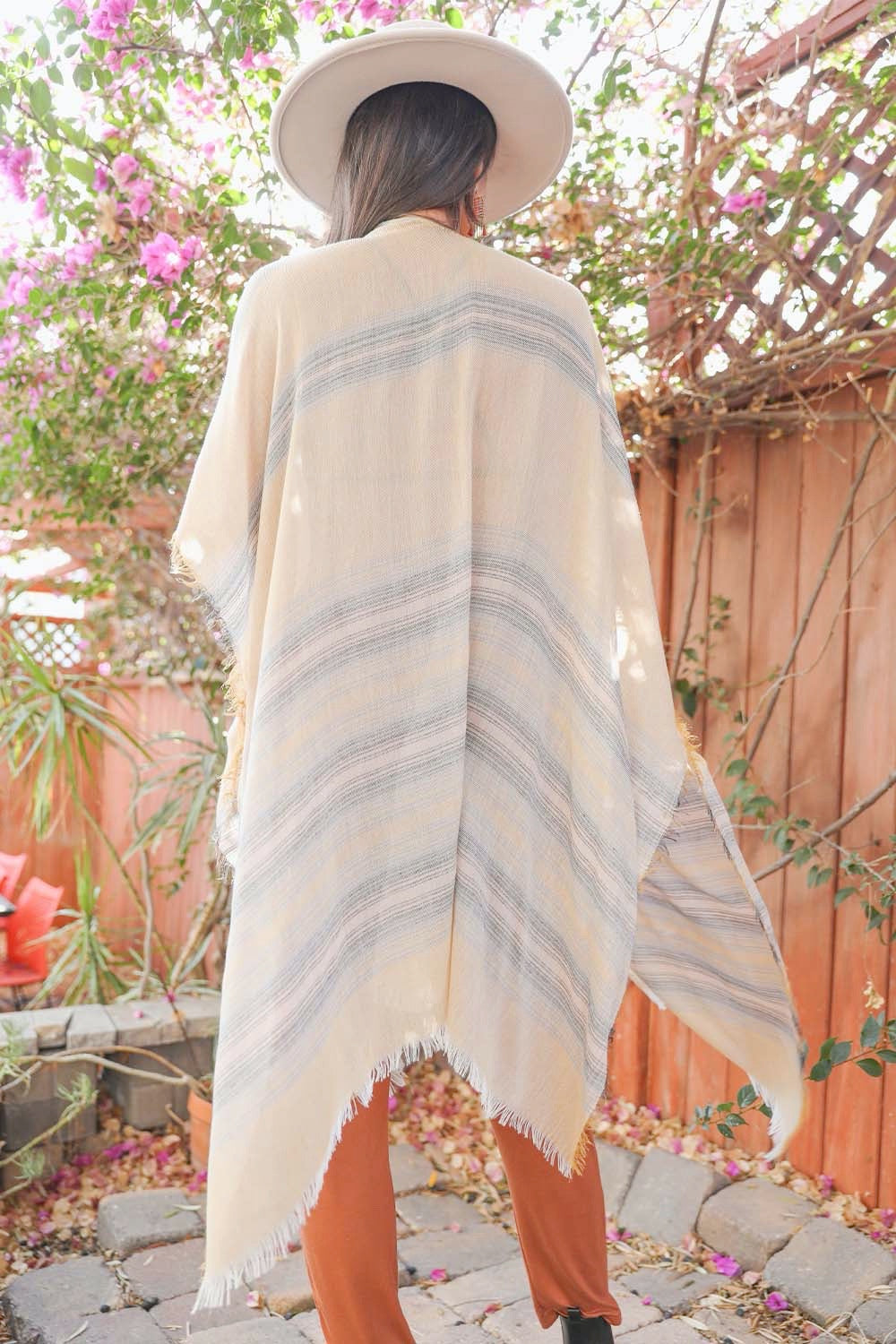 A vibrant striped frayed kimono featuring colorful patterns, perfect for layering and keeping warm on cool nights.
