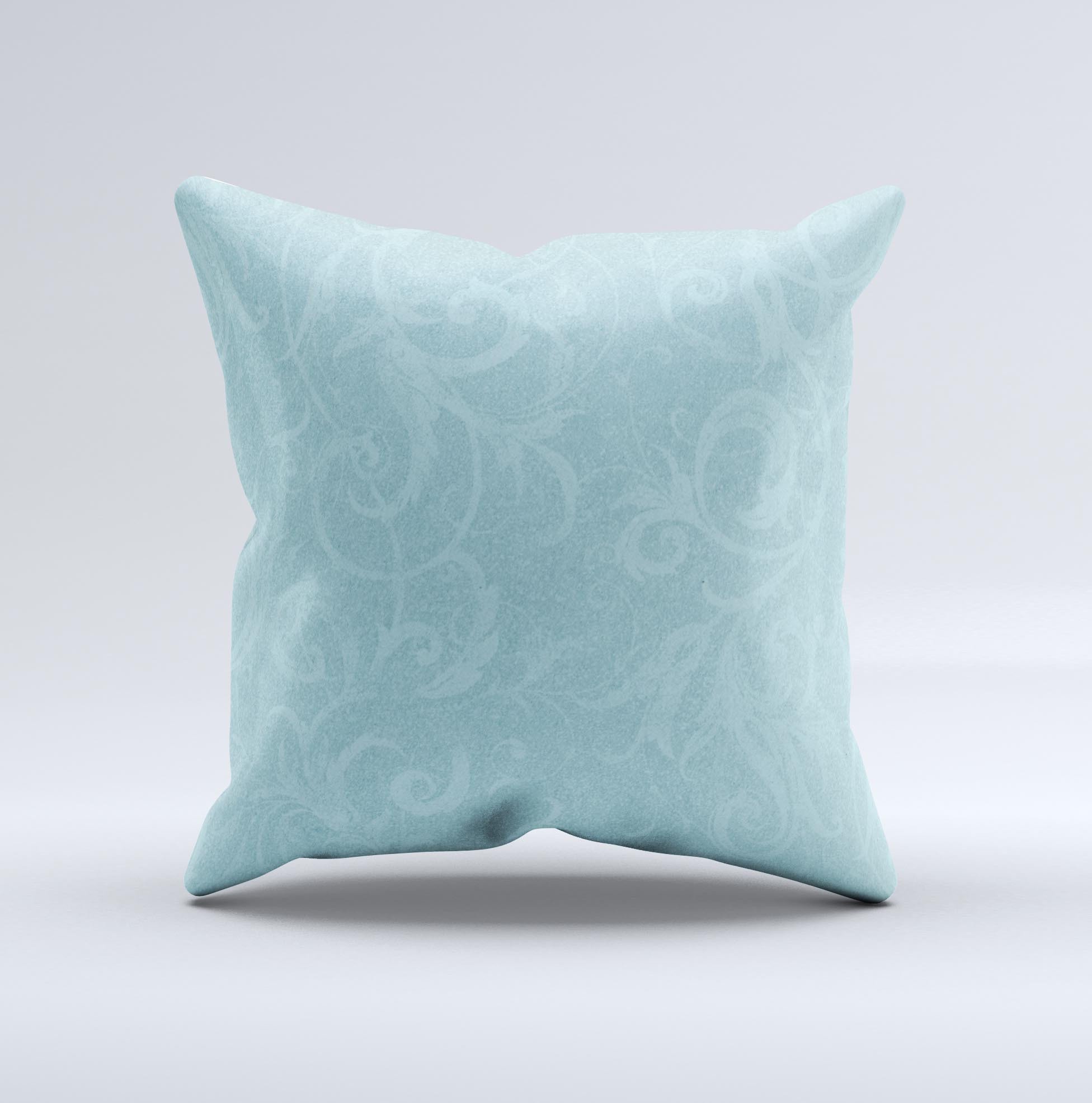 A decorative throw pillow featuring a subtle blue floral design, laced with intricate patterns, showcasing its handmade quality and soft texture.