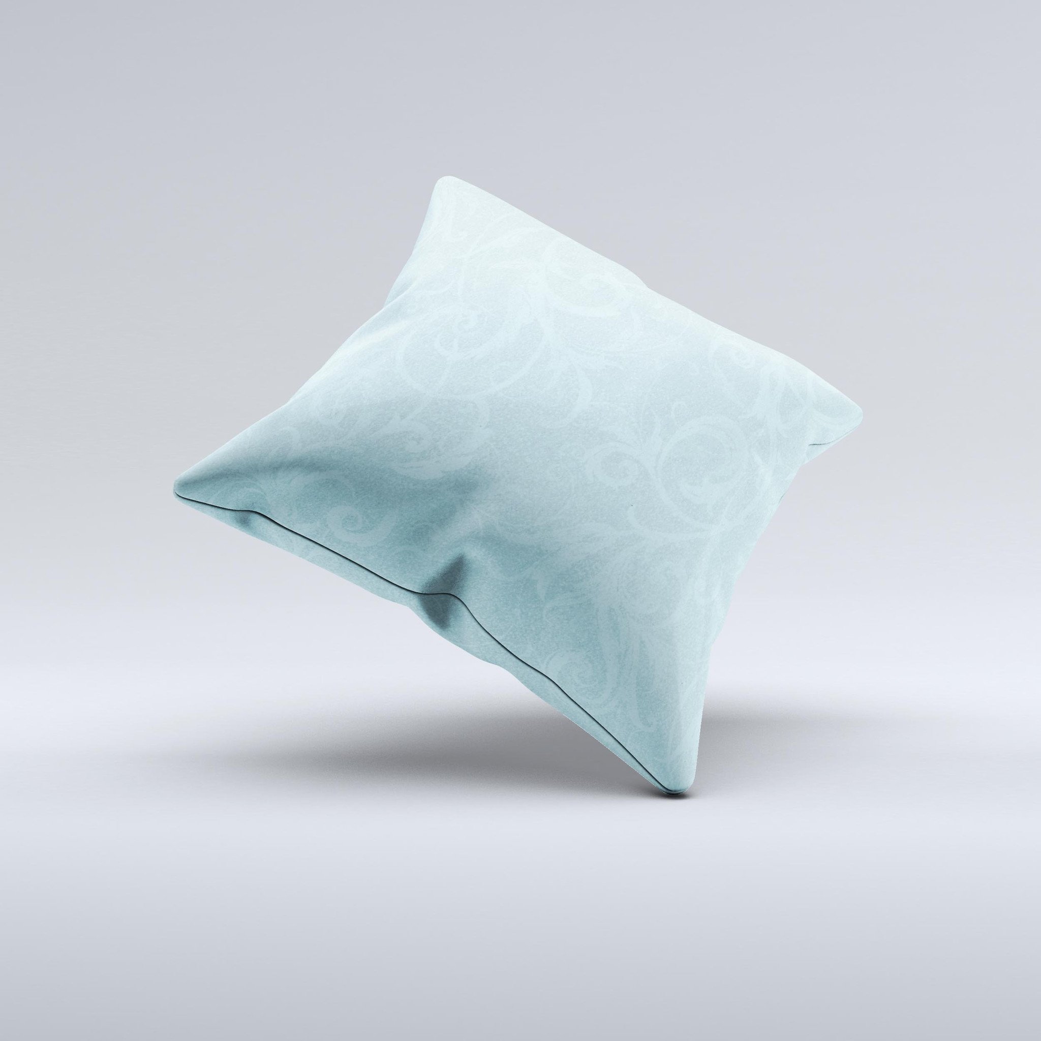 A decorative throw pillow featuring a subtle blue floral design, laced with intricate patterns, showcasing its handmade quality and soft texture.
