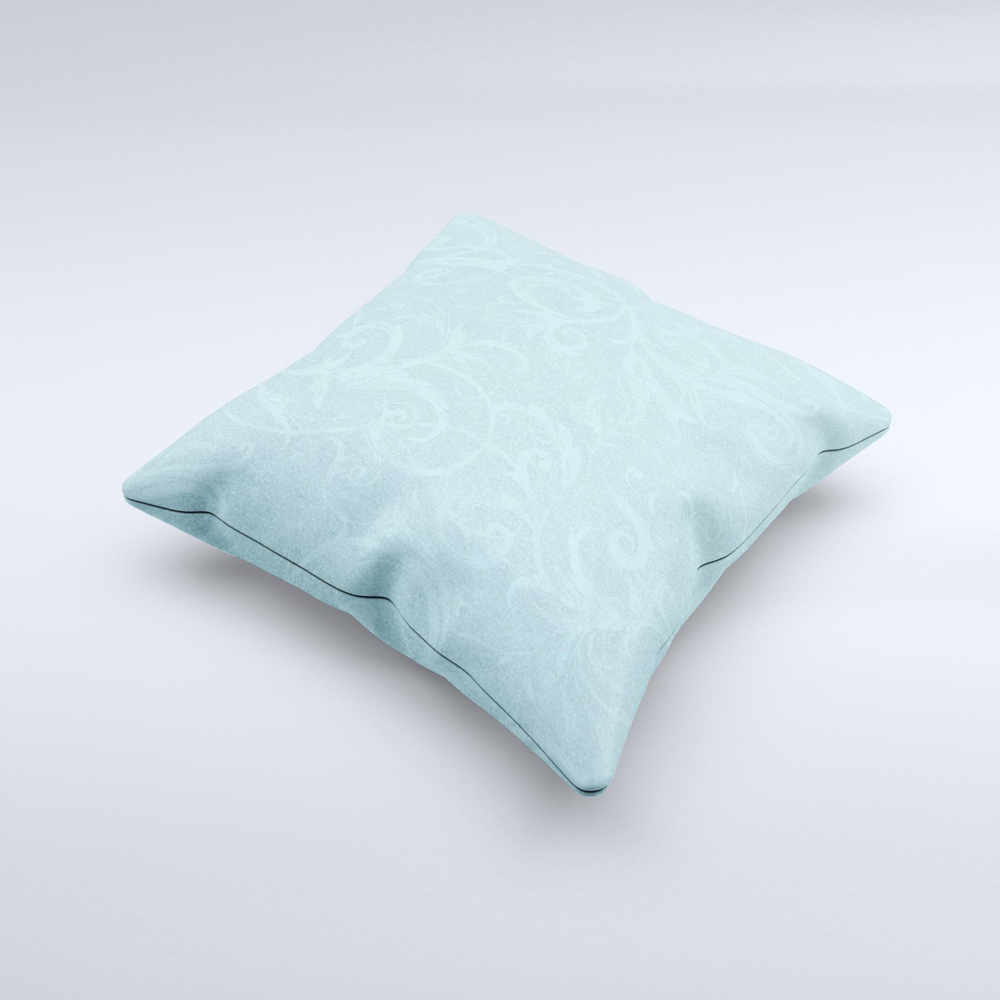 A decorative throw pillow featuring a subtle blue floral design, laced with intricate patterns, showcasing its handmade quality and soft texture.