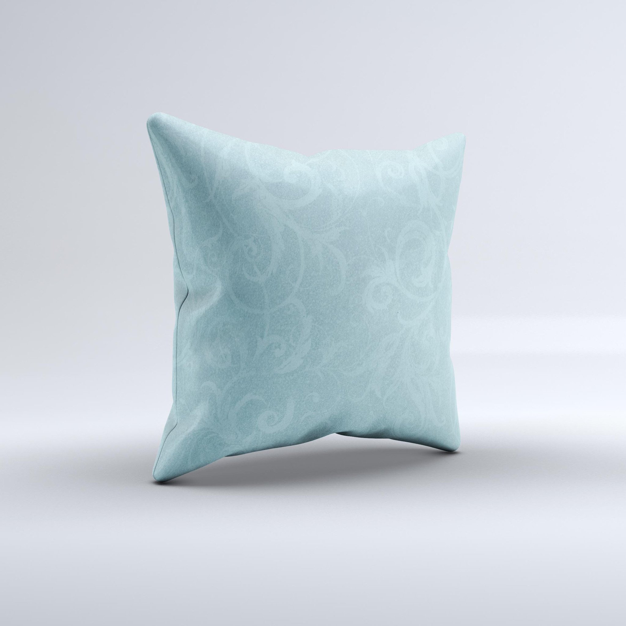 A decorative throw pillow featuring a subtle blue floral design, laced with intricate patterns, showcasing its handmade quality and soft texture.