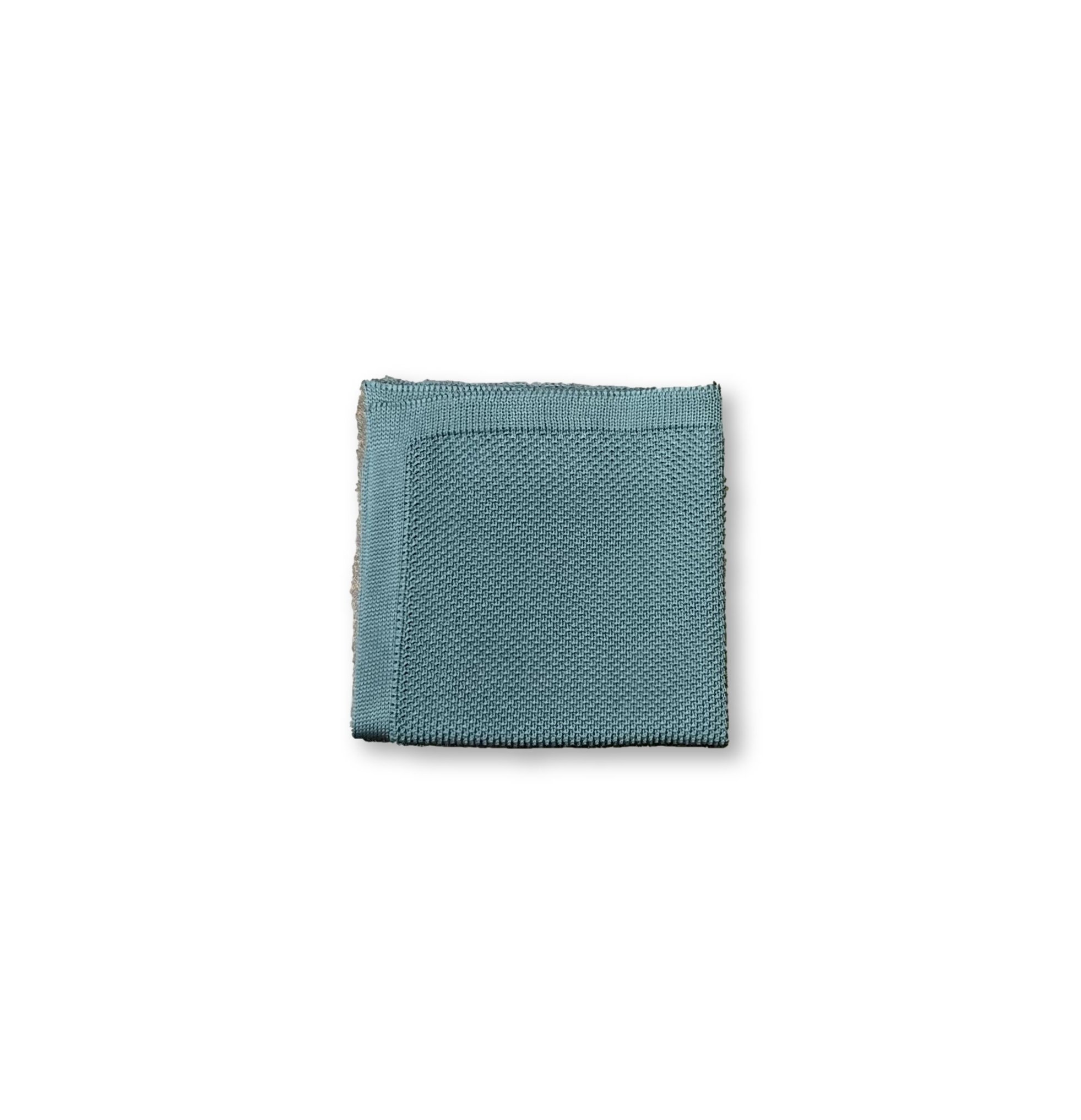 Teal knitted pocket square displayed elegantly, showcasing its vibrant color and soft texture.