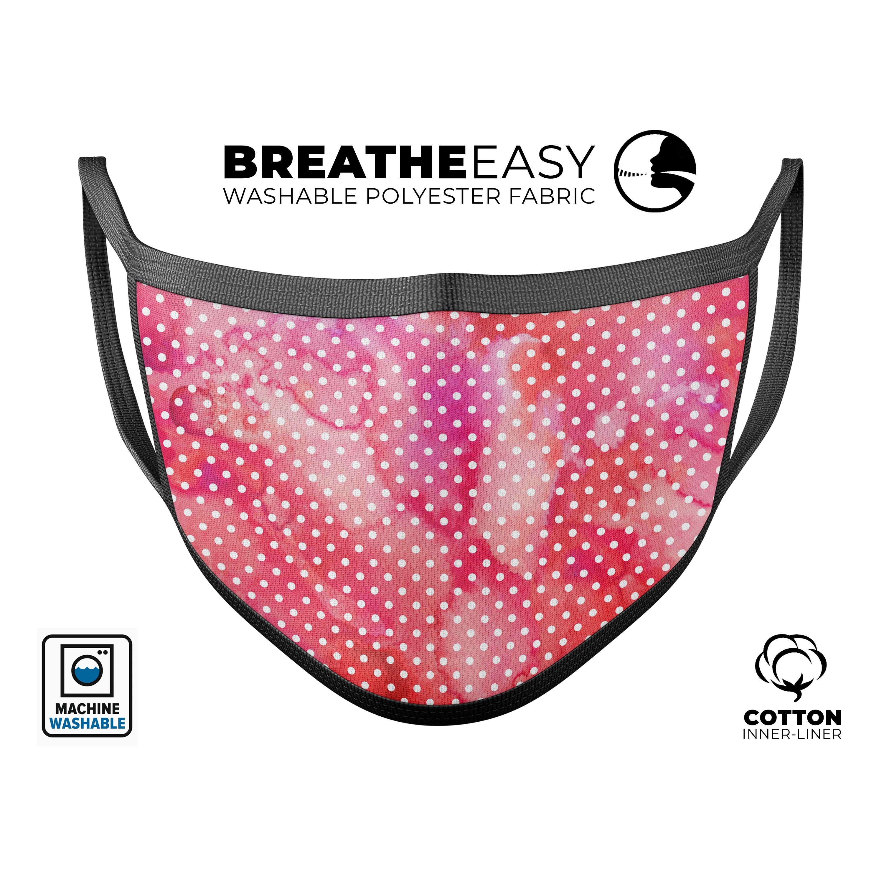 A vibrant red and pink watercolor polka dots face mask, showcasing its unique design and adjustable ear loops.