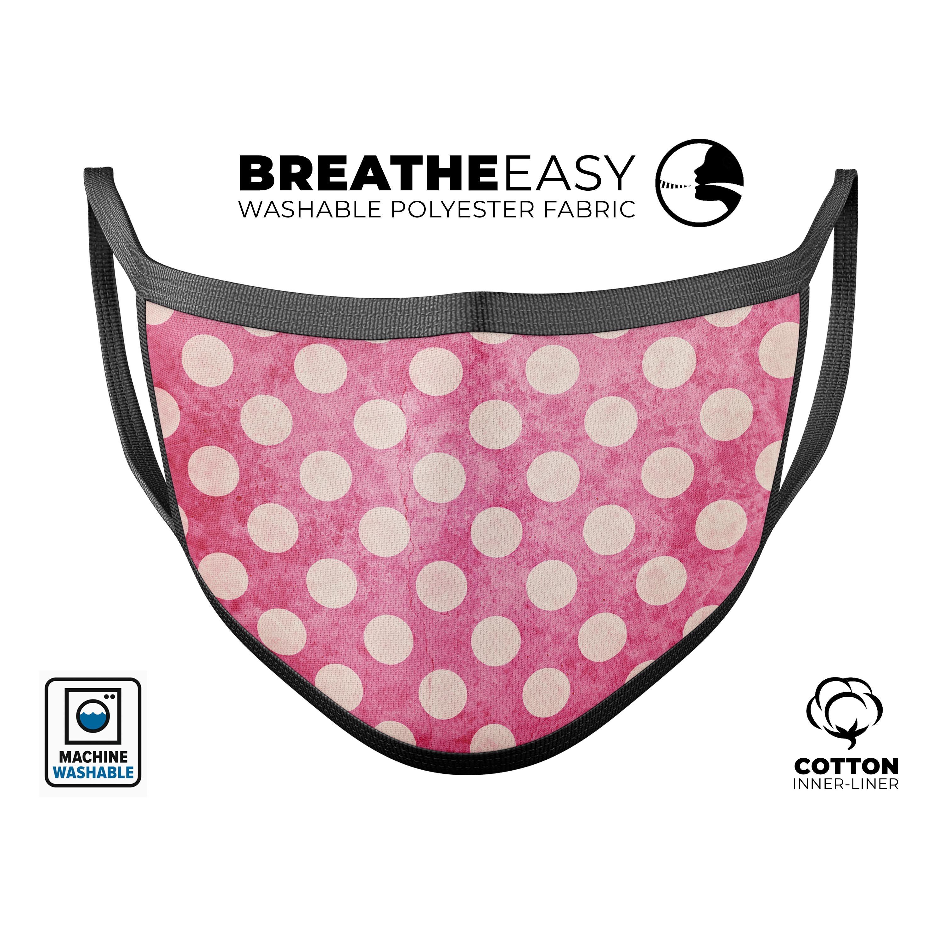 A stylish white polka dots face mask over a grungy pink background, showcasing its unique design and comfortable fit.