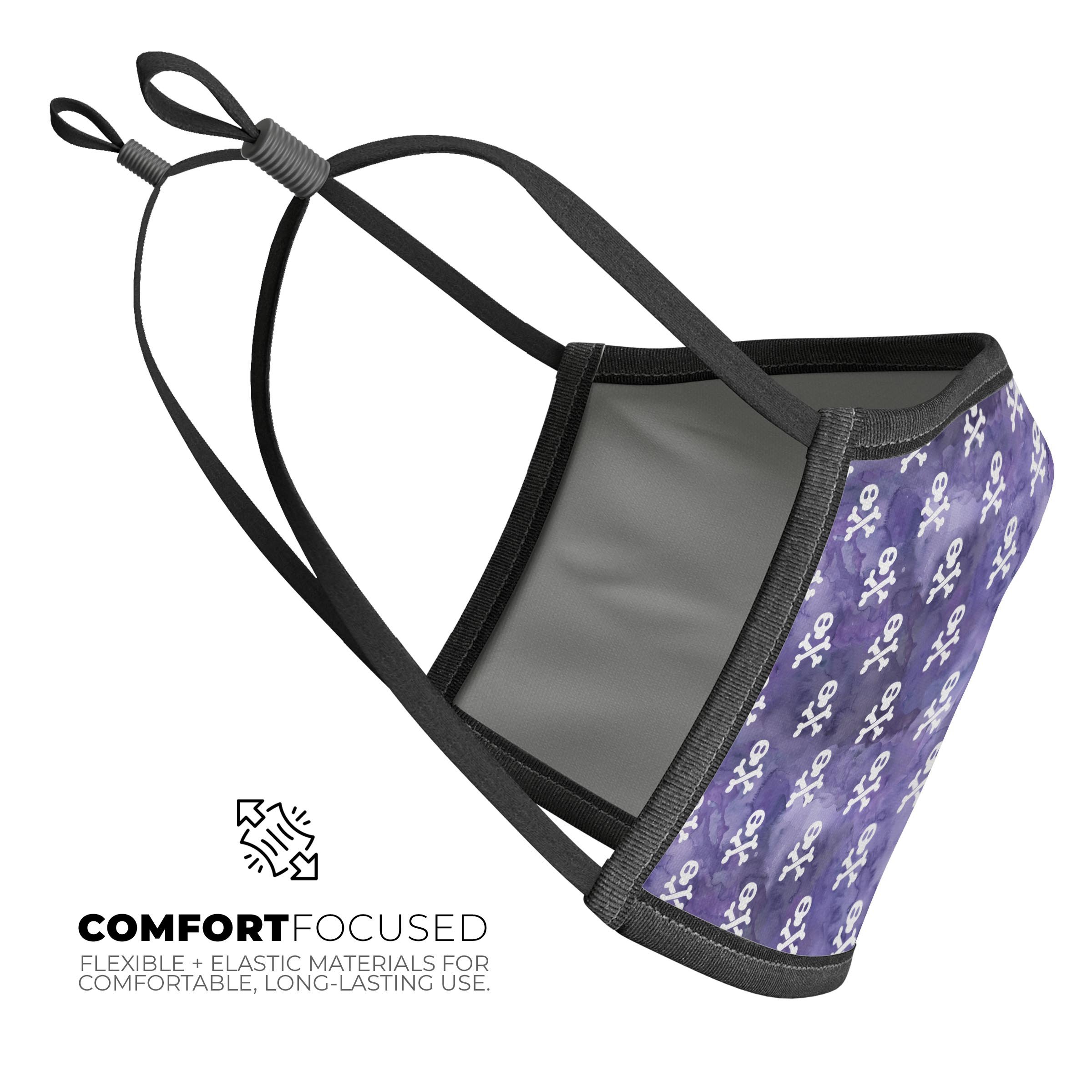 A stylish unisex mouth cover featuring white skulls on a vibrant purple watercolor background, made in the USA.