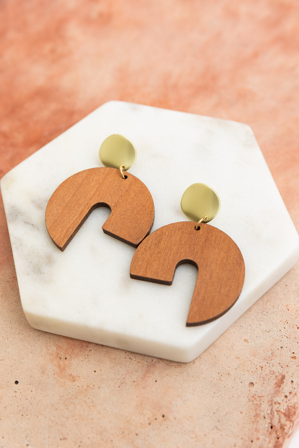 A pair of stylish wooden modern arch shaped earrings showcasing a contemporary design with a natural wood finish.