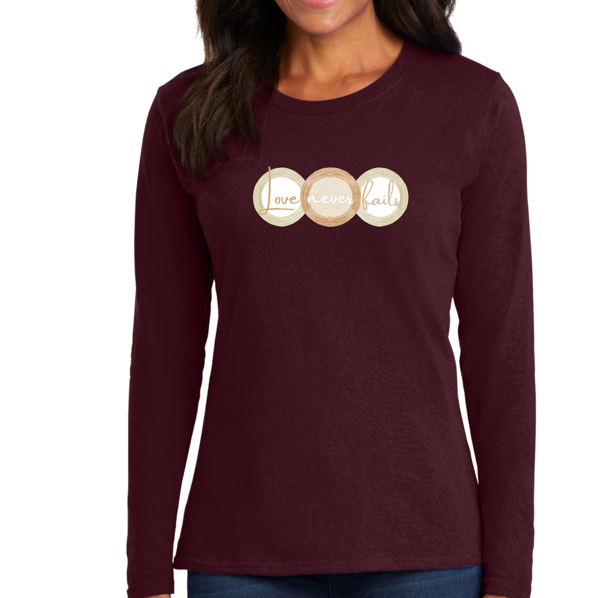 Womens Long Sleeve Graphic T-shirt in pastel brown featuring 'Love Never Fails' design with circular shapes in beige and green.
