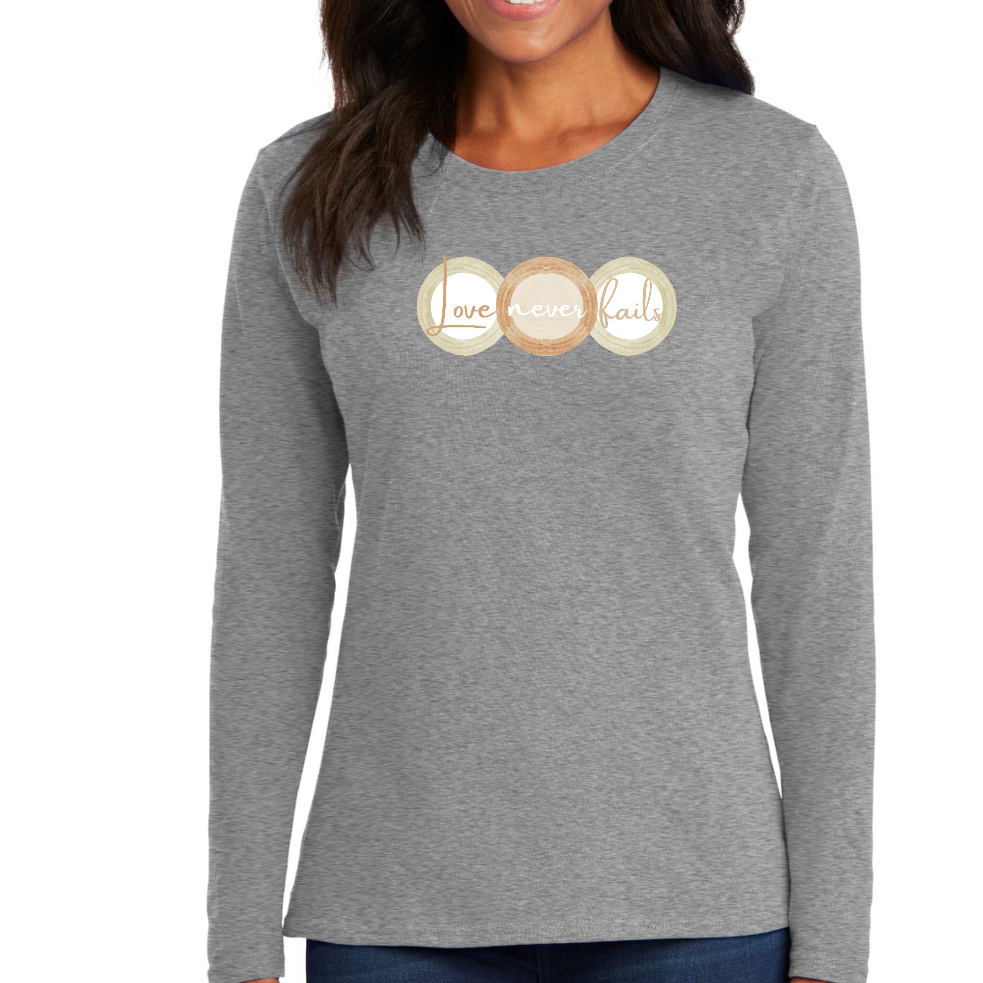 Womens Long Sleeve Graphic T-shirt in pastel brown featuring 'Love Never Fails' design with circular shapes in beige and green.