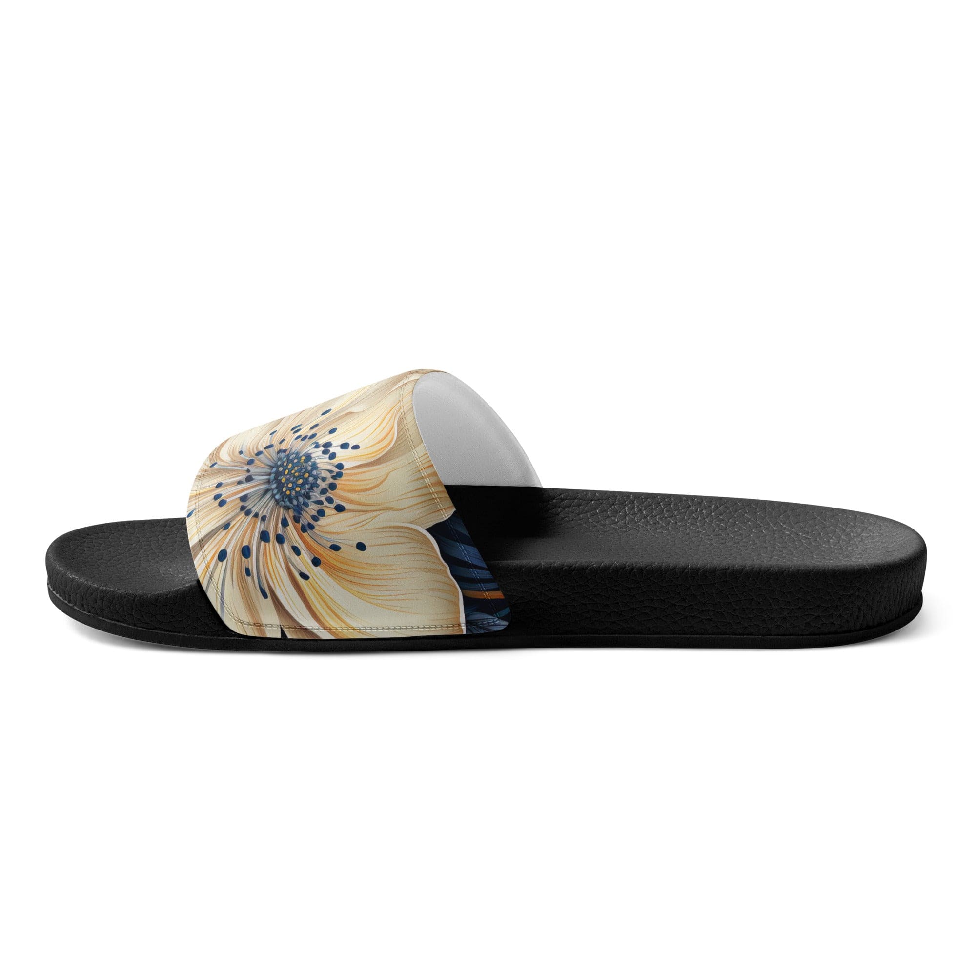 A pair of women's slides featuring a blue floral block print illustration, showcasing a cushioned upper strap and textured footbed.