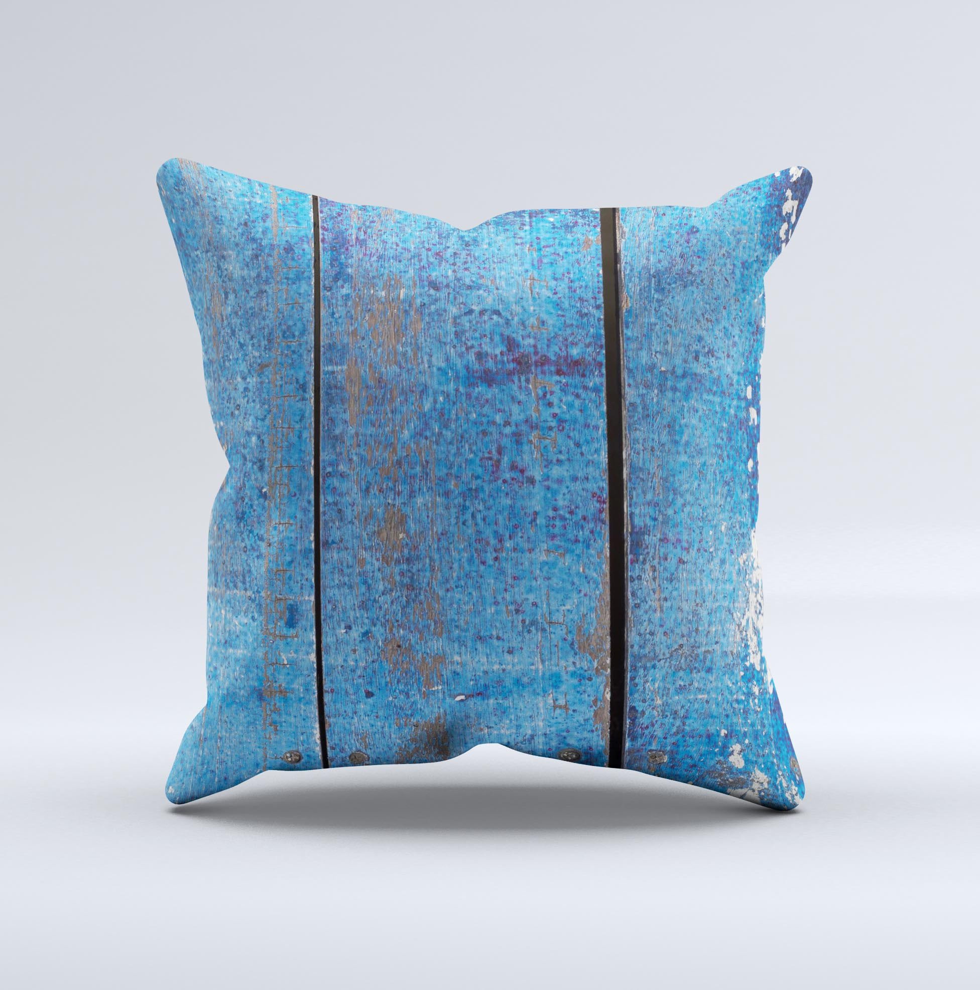 Handcrafted decorative throw pillow featuring a worn blue paint design on wooden planks, showcasing unique imperfections and high-quality fabric.