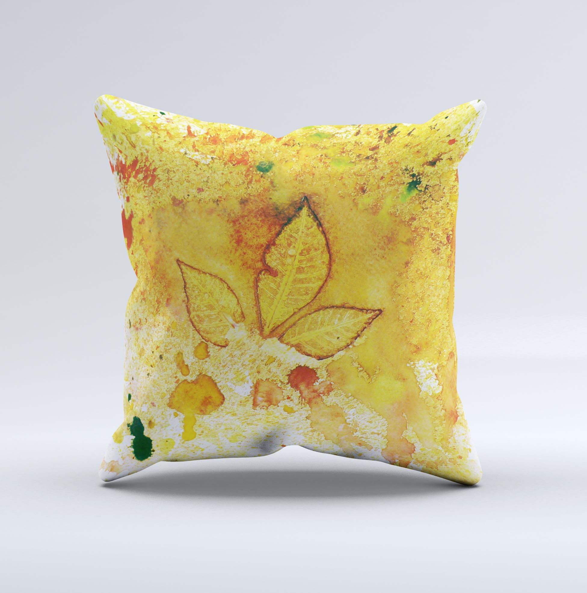 A vibrant yellow leaf-imprinted decorative throw pillow with paint splatter design, handcrafted in Virginia, showcasing unique artistic details.