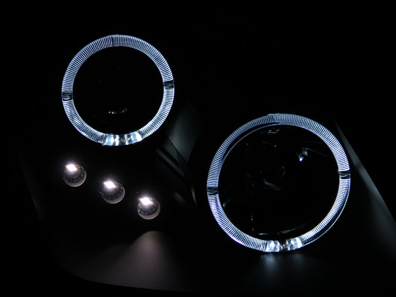ANZO projector headlights for 1997-2001 Honda Prelude featuring black housing, halo rings, and LED lights.