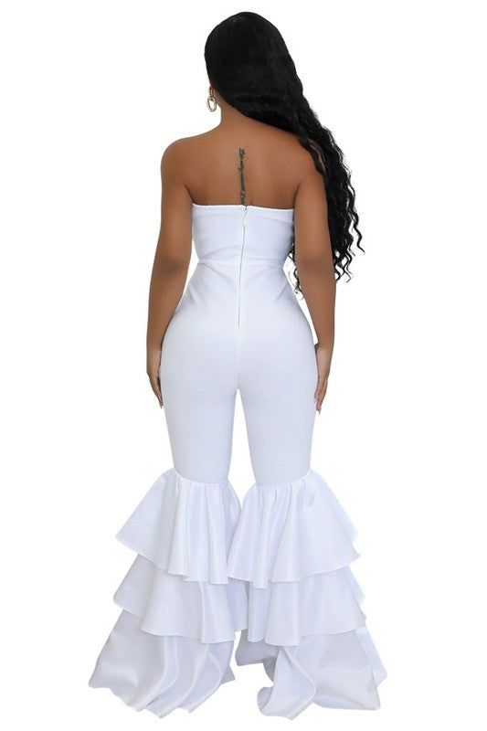 A stylish women fashion party jumpsuit featuring a strapless design, belted wide legs, and fluttering layered ruffles.