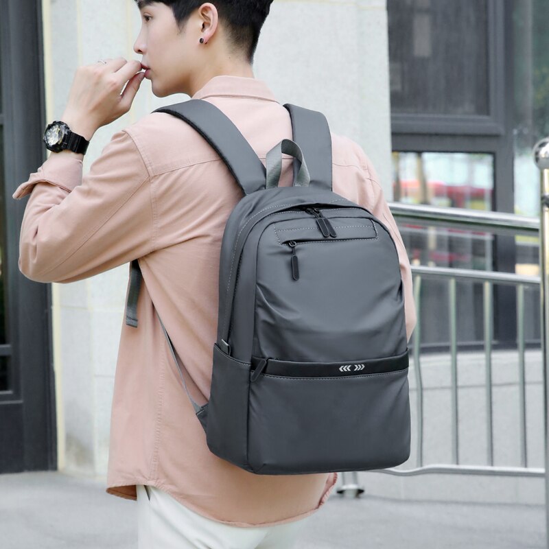 A stylish business backpack for men made of high-quality nylon, featuring multiple pockets and designed to hold a 15.6-inch laptop.