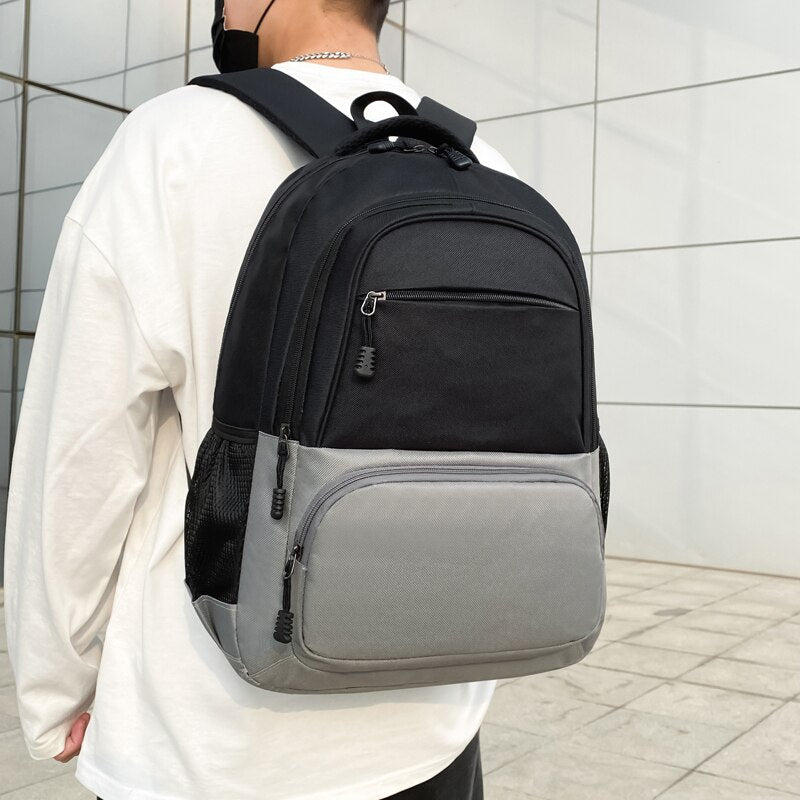 Men's nylon backpack featuring a stylish panelled design, multiple compartments, and a soft handle, ideal for daily use and travel.