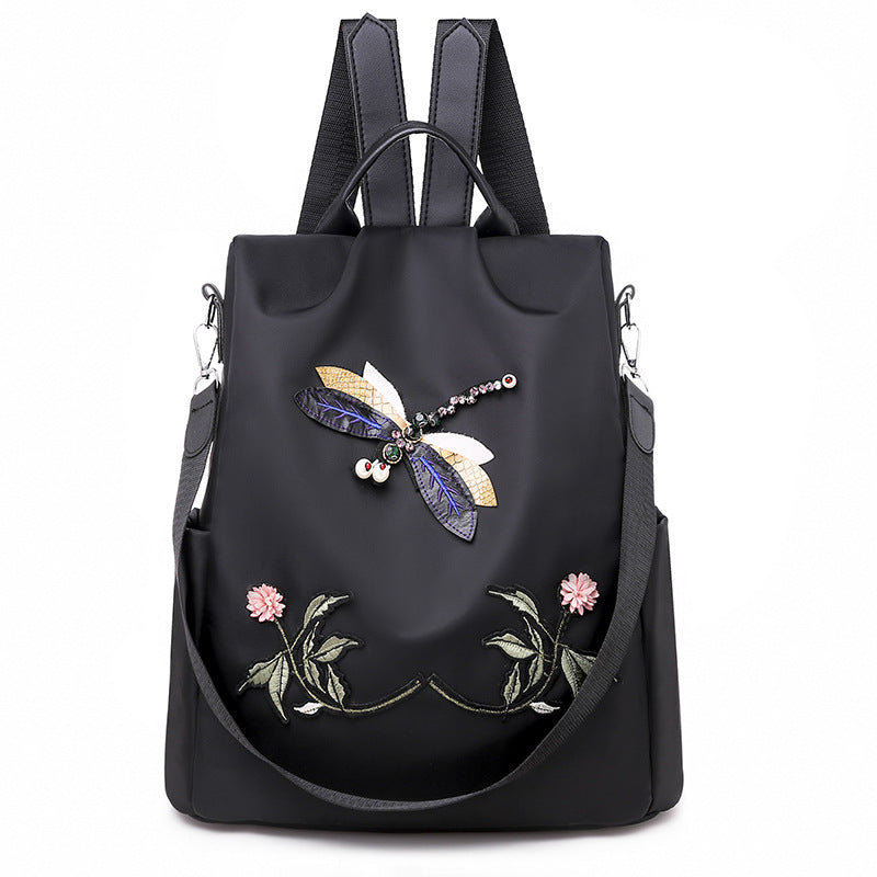 Oxford cloth travel backpack featuring an embroidered dragonfly pattern, showcasing its stylish design and durable construction.