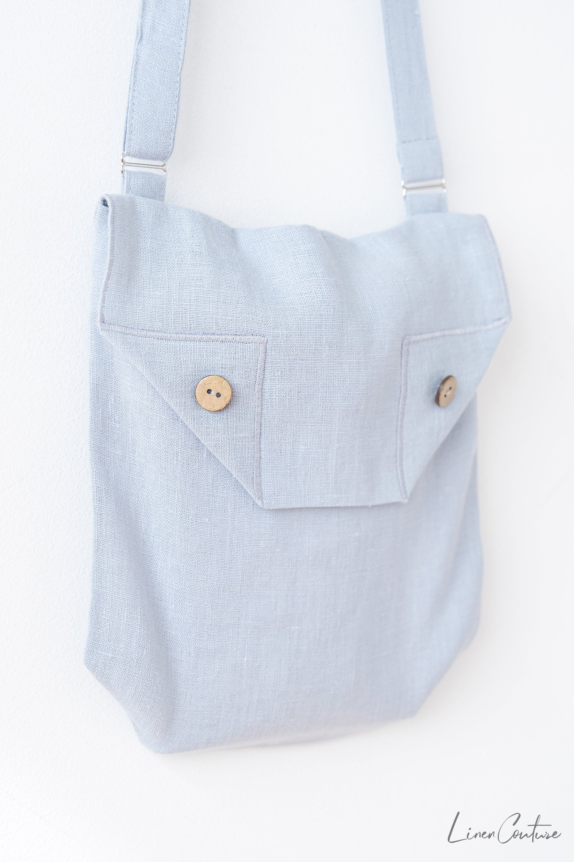 Ice Blue Linen Shoulder Bag featuring coconut buttons and an adjustable strap, showcasing elegant craftsmanship and earthy sophistication.