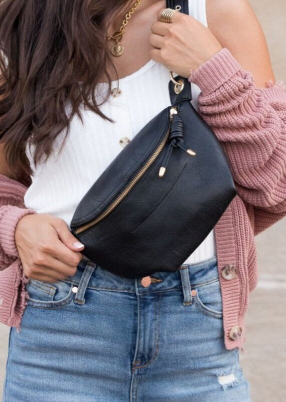A stylish Carryall Travel Fanny Pack made of soft vegan leather, featuring gold hardware and an adjustable strap, perfect for travel and everyday use.