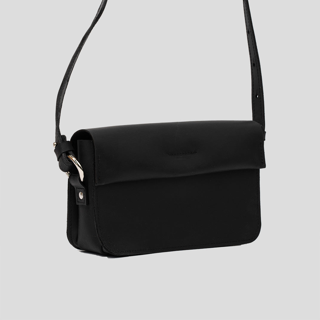 A stylish black leather shoulder bag with a minimal design, featuring an adjustable strap and spacious interior for daily essentials.