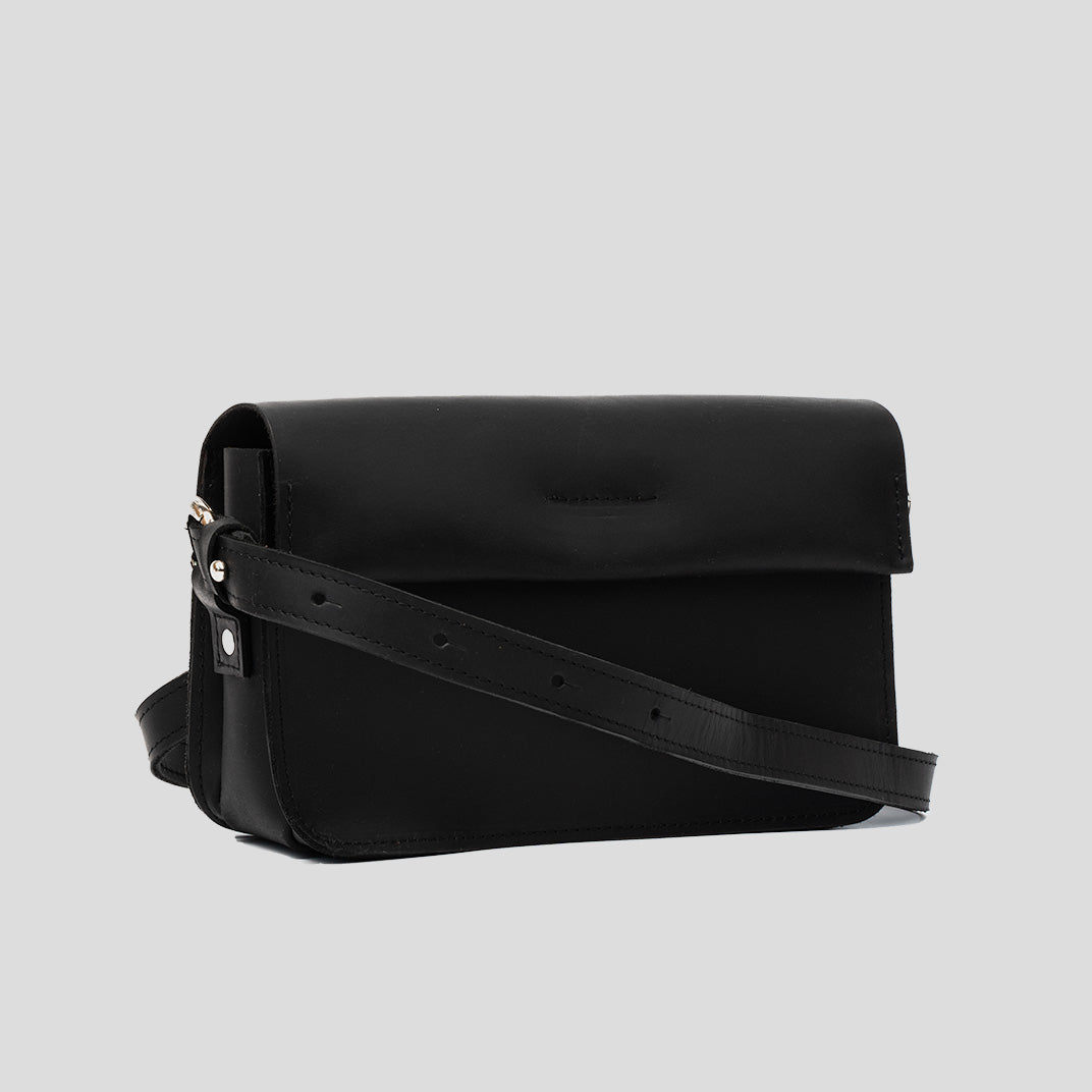 A stylish black leather shoulder bag with a minimal design, featuring an adjustable strap and spacious interior for daily essentials.
