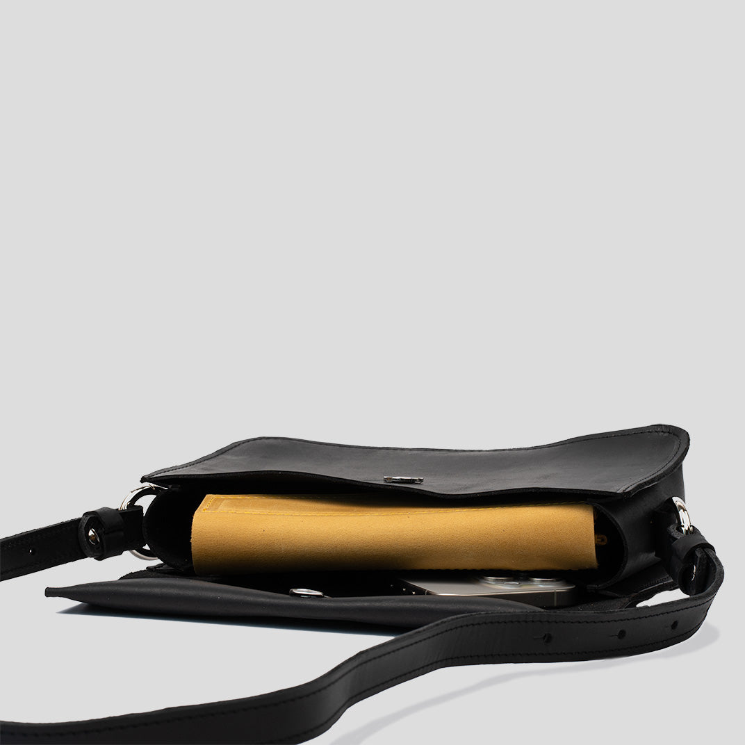 A stylish black leather shoulder bag with a minimal design, featuring an adjustable strap and spacious interior for daily essentials.