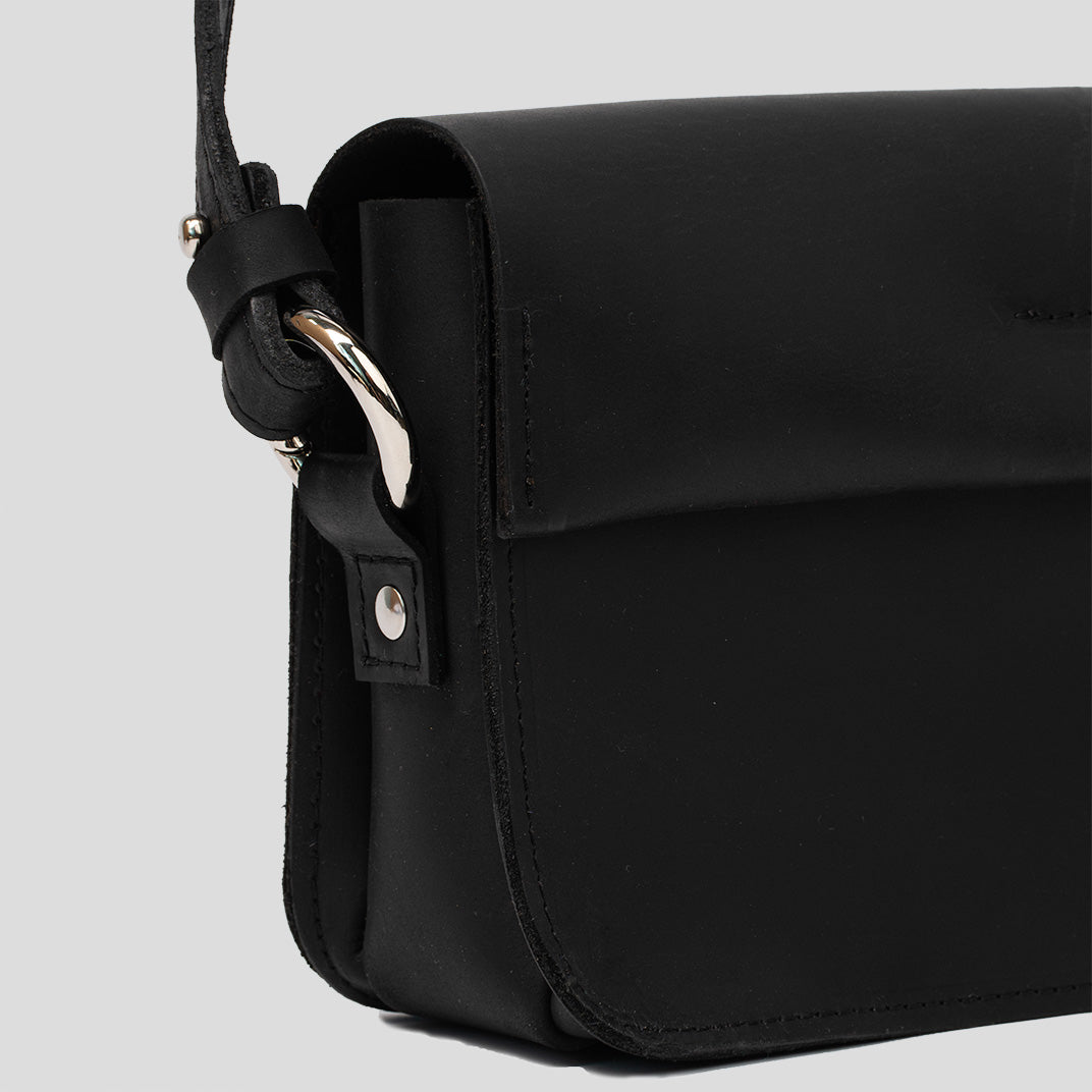 A stylish black leather shoulder bag with a minimal design, featuring an adjustable strap and spacious interior for daily essentials.