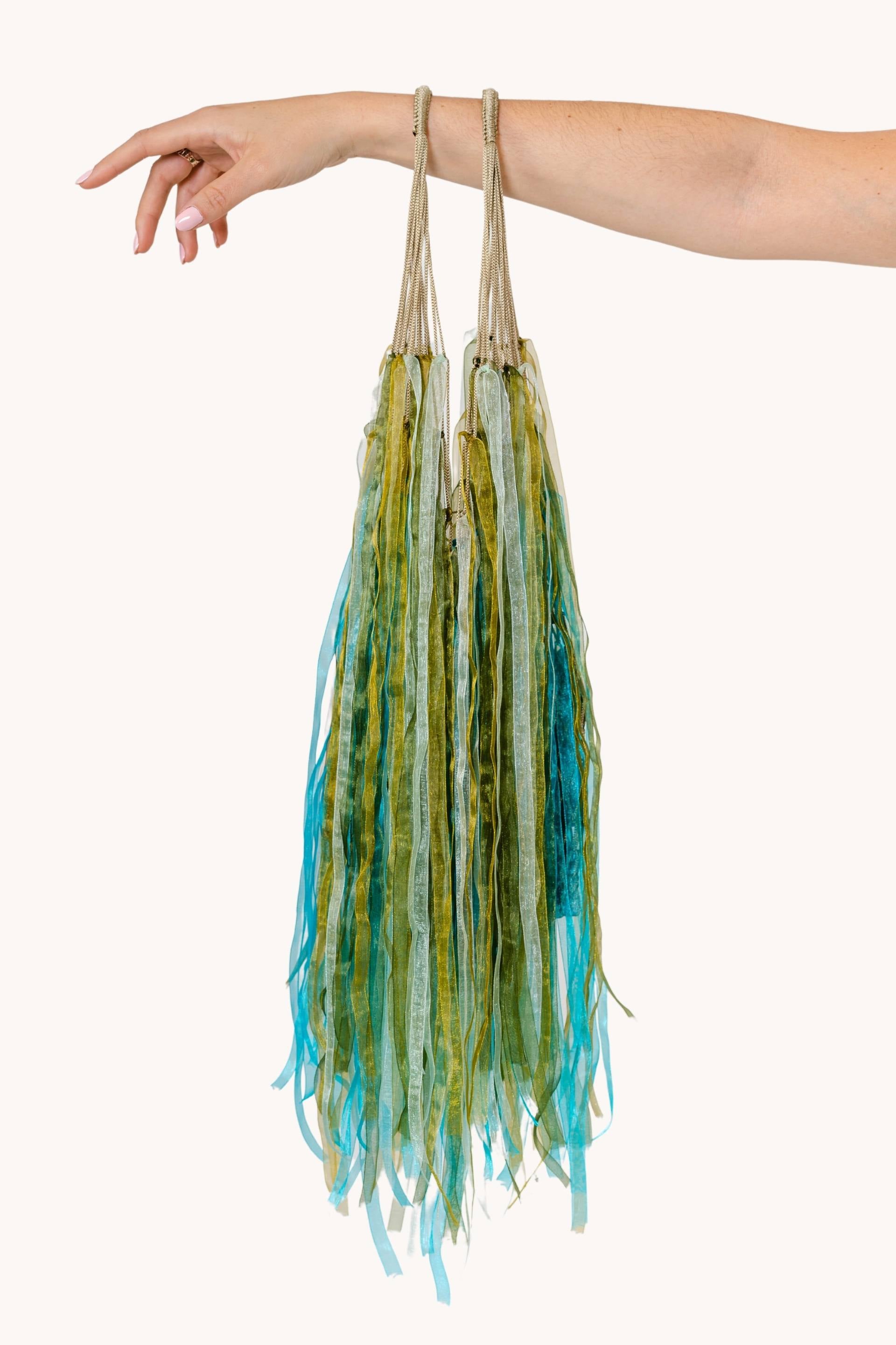 A beautiful Flower Hat Jellyfish showcasing its translucent bell and dark pinstripes, surrounded by shades of green and blue.