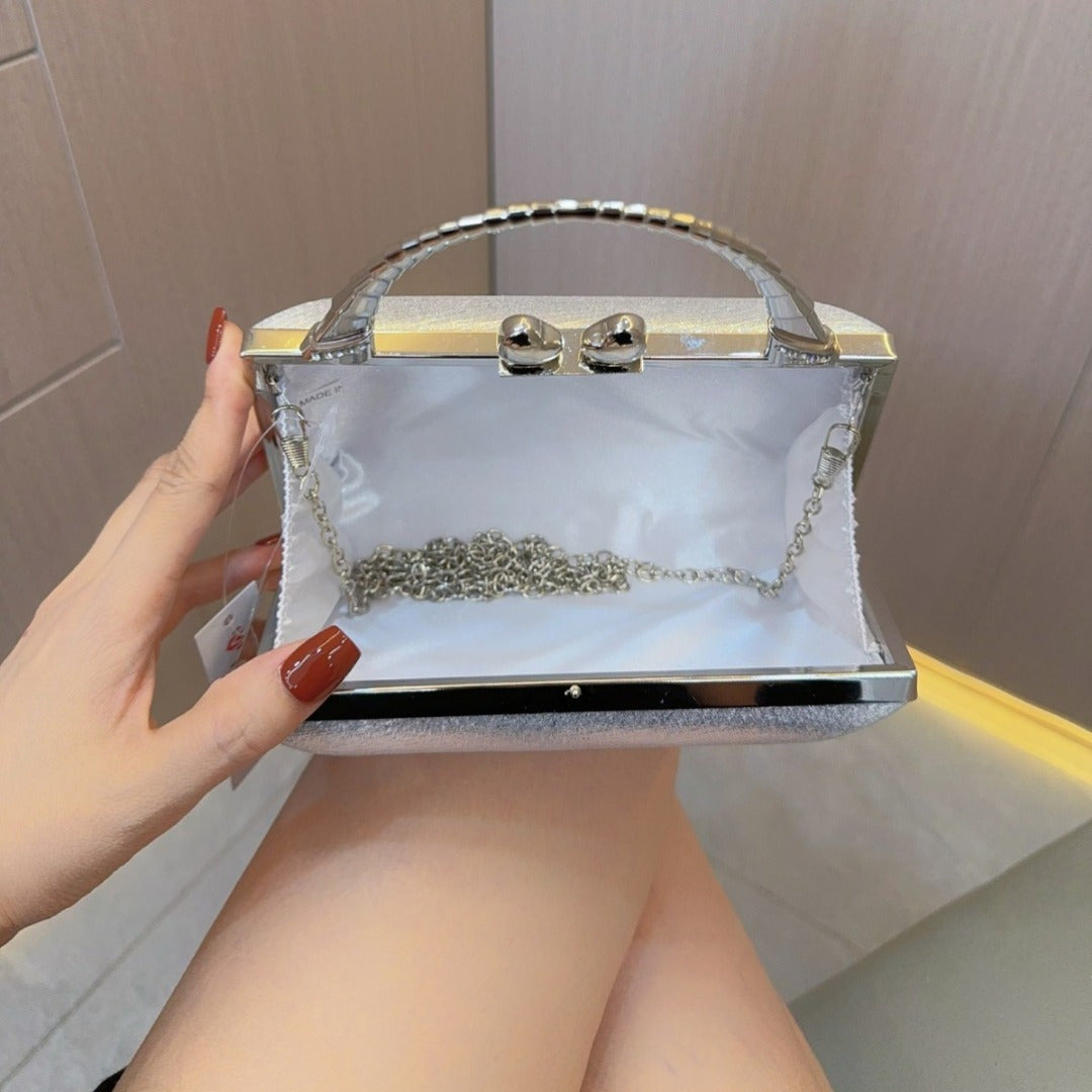 Elegant gold and silver clutch purse with diamond clasps, featuring a crossbody strap, perfect for evening events.