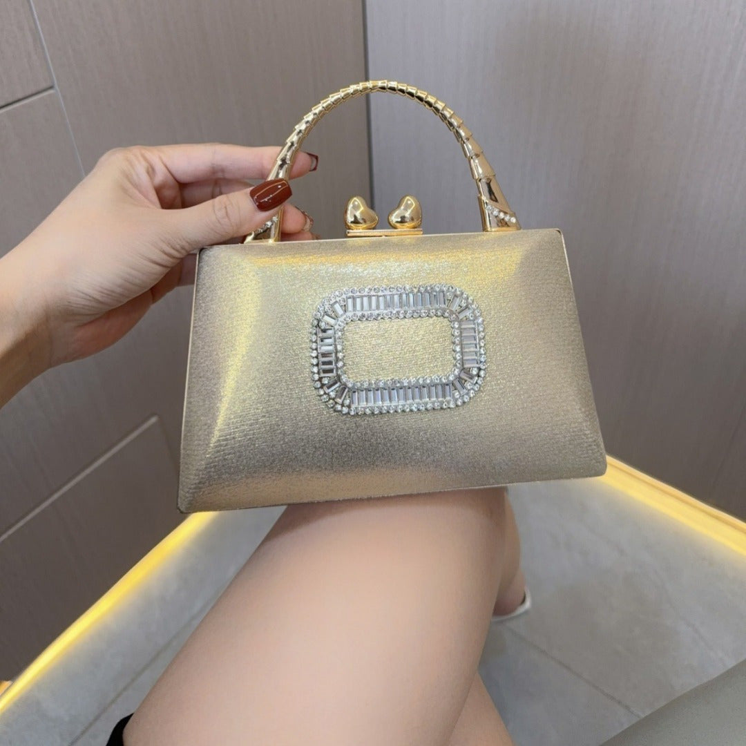 Elegant gold and silver clutch purse with diamond clasps, featuring a crossbody strap, perfect for evening events.